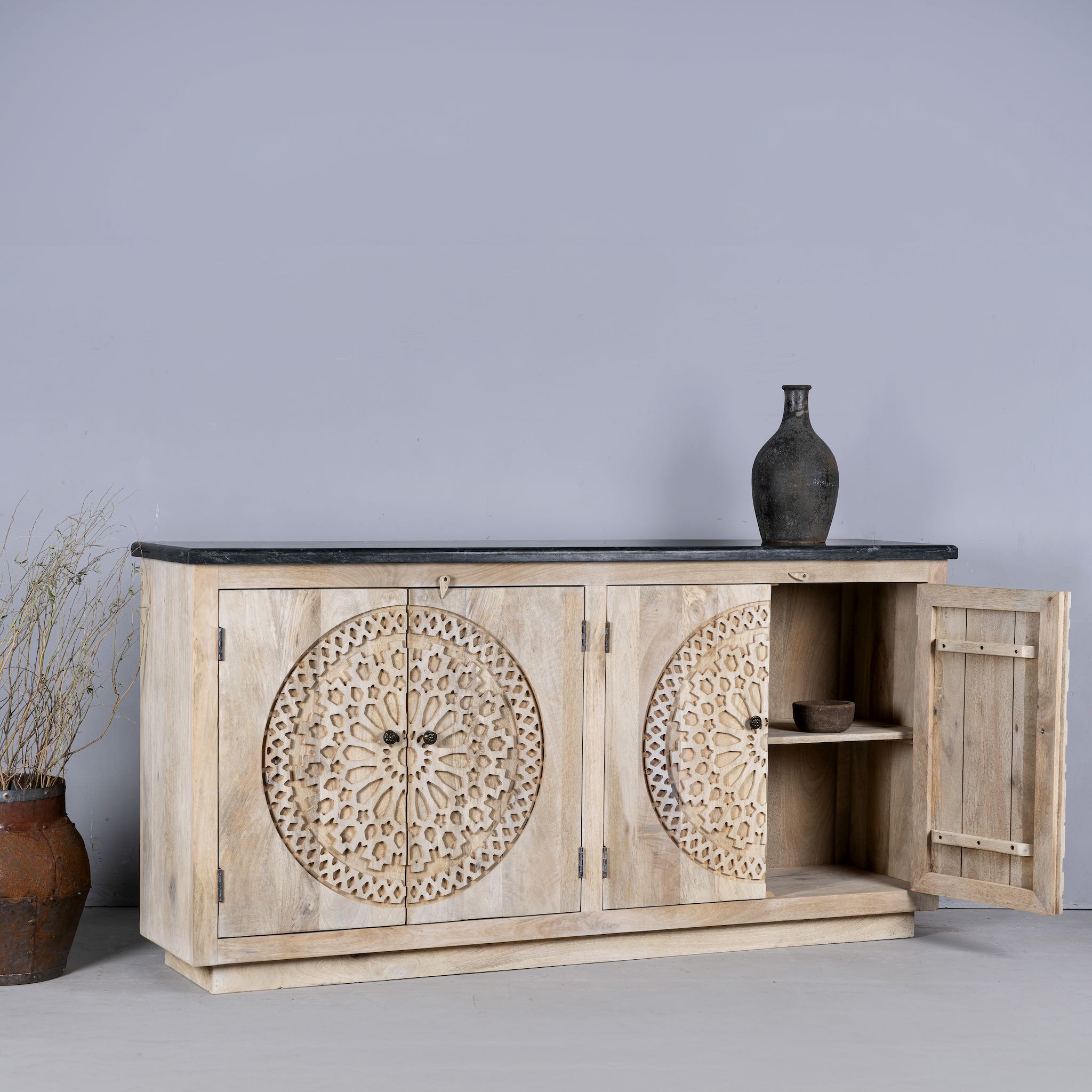 Open door image of a handcrafted acacia wood sideboard with black marble top and ornate hand-carved doors – a luxurious piece of wood carved furniture.