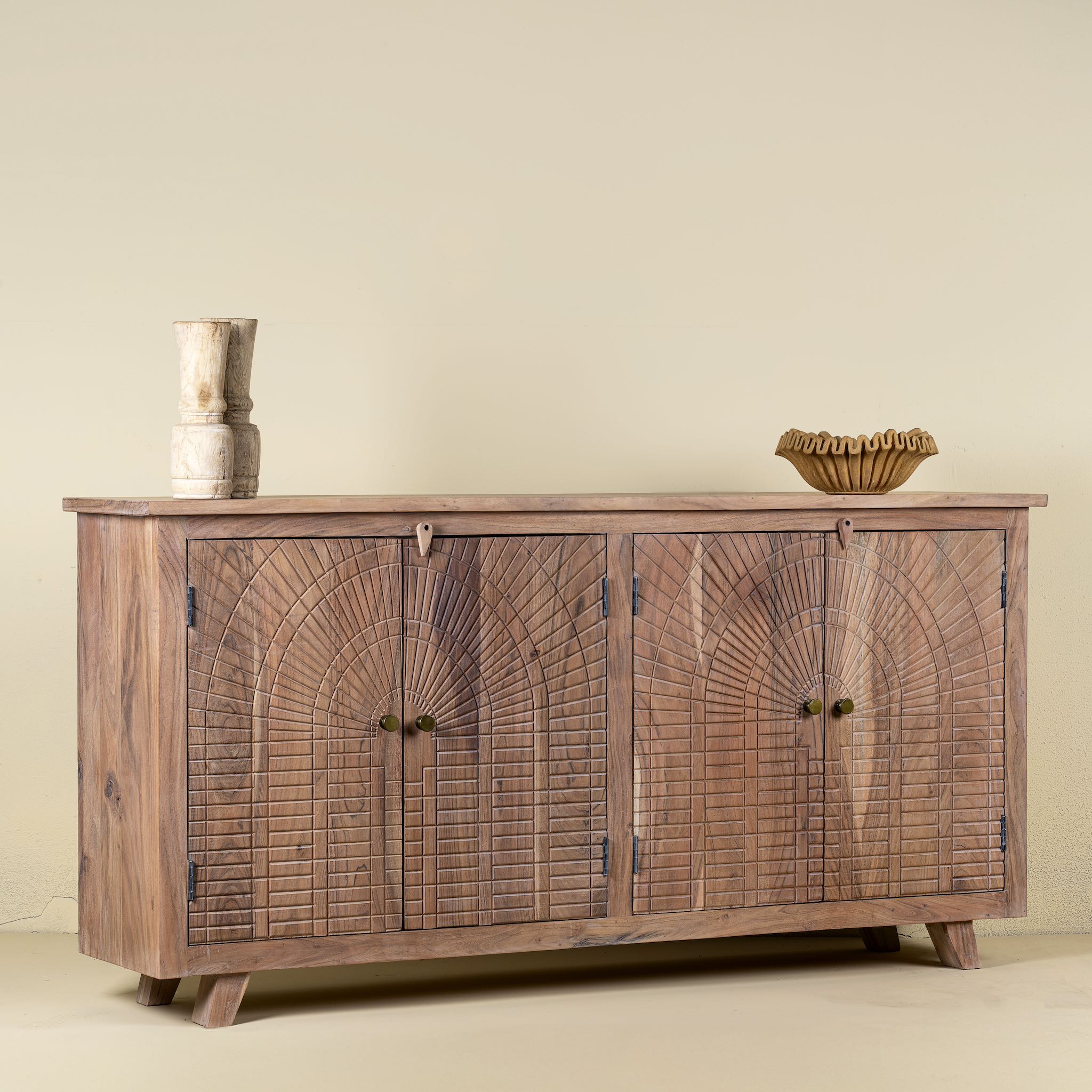 side view of a sideboard with artisanal inspired carvings on 4 doors made of acacia wood.