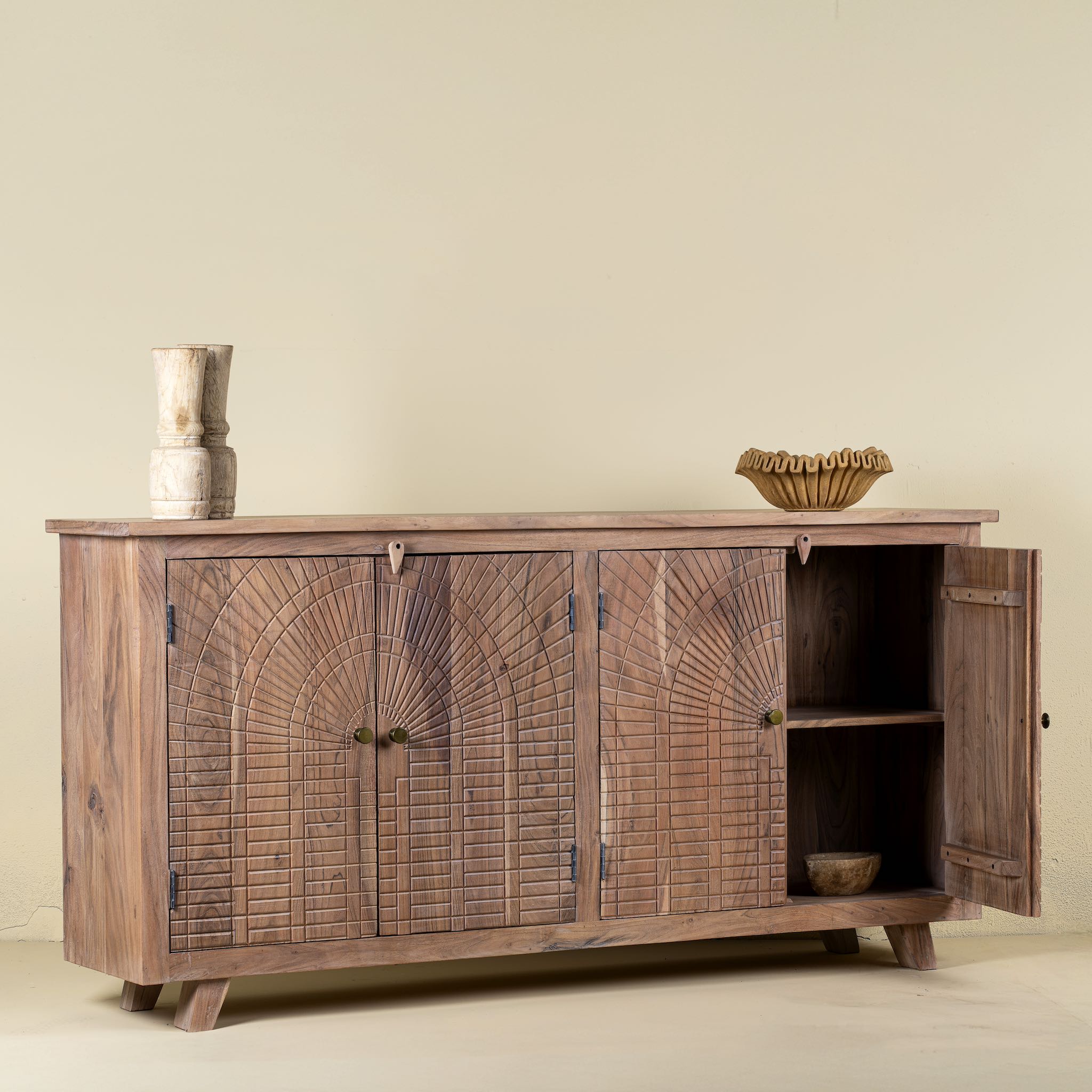 Open door picture of a sideboard with artisanal inspired carvings on 4 doors made of acacia wood.