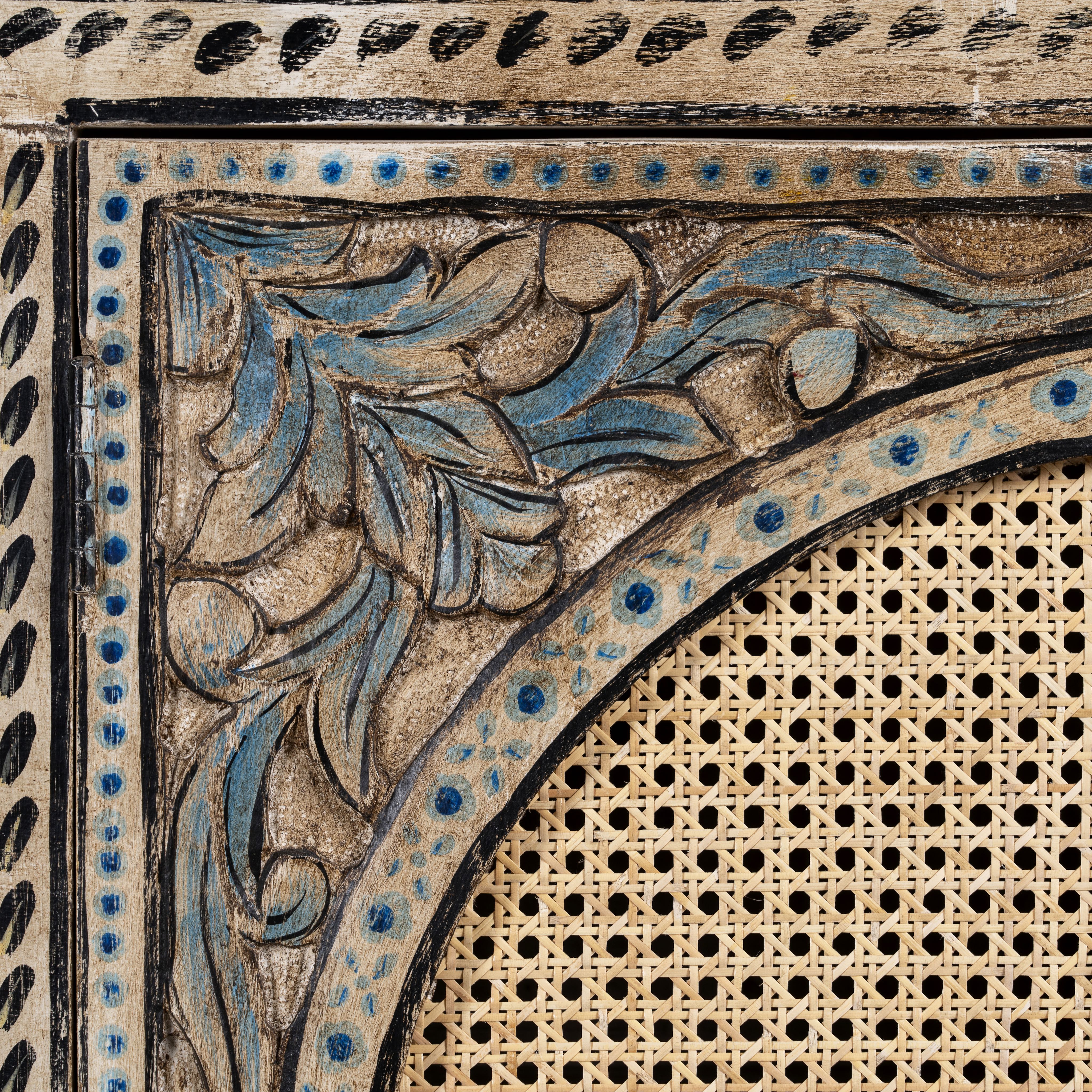 Close up image of a hand painted sideboard in blue and beige with rattan door inserts; unique furniture for boho style interiors, 120 × 40 × 92 cm.