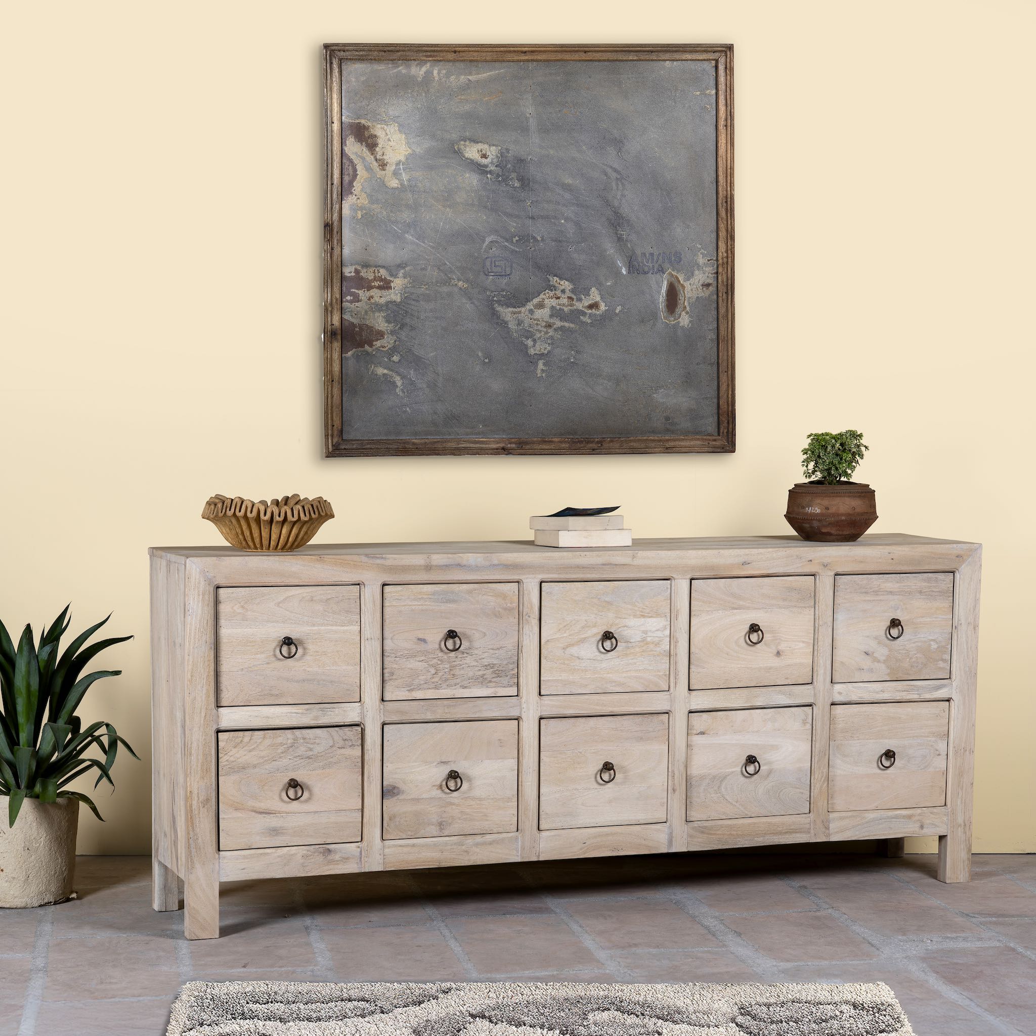 Side angle image of a sandblasted reclaimed mango wood chest of drawers with ten drawers, perfect as bedroom furniture or part of a relaxed Ibiza-style interior.
