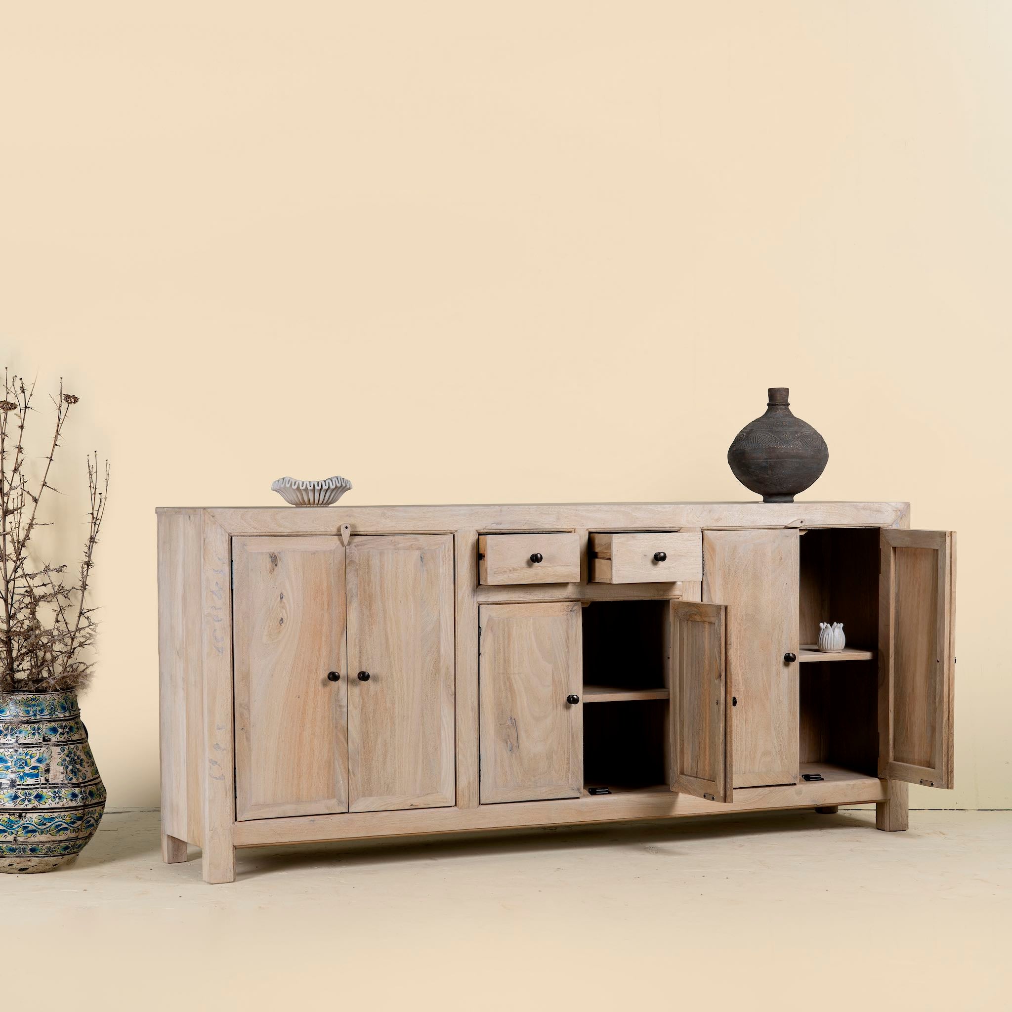 Open drawers and doors image of a sandblasted wooden sideboard with three compartments and two small drawers, Ibiza style living room furniture in light natural finish, 200×40×90 cm.