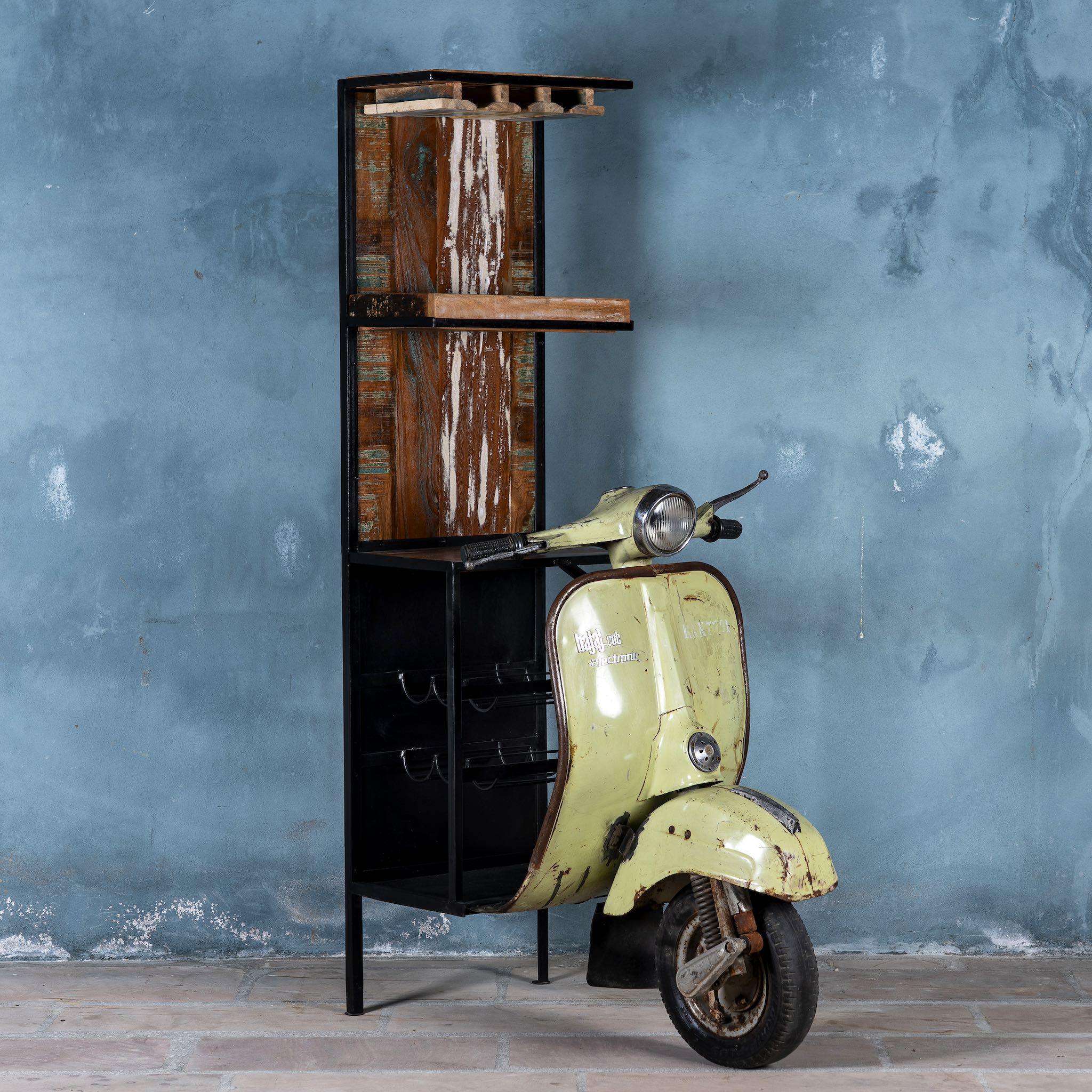 Side angle image o Ahana high bar table featuring the front half of a vintage Bajaj scooter, with tall wooden shelving and an industrial metal frame, designed for stylish bar storage.