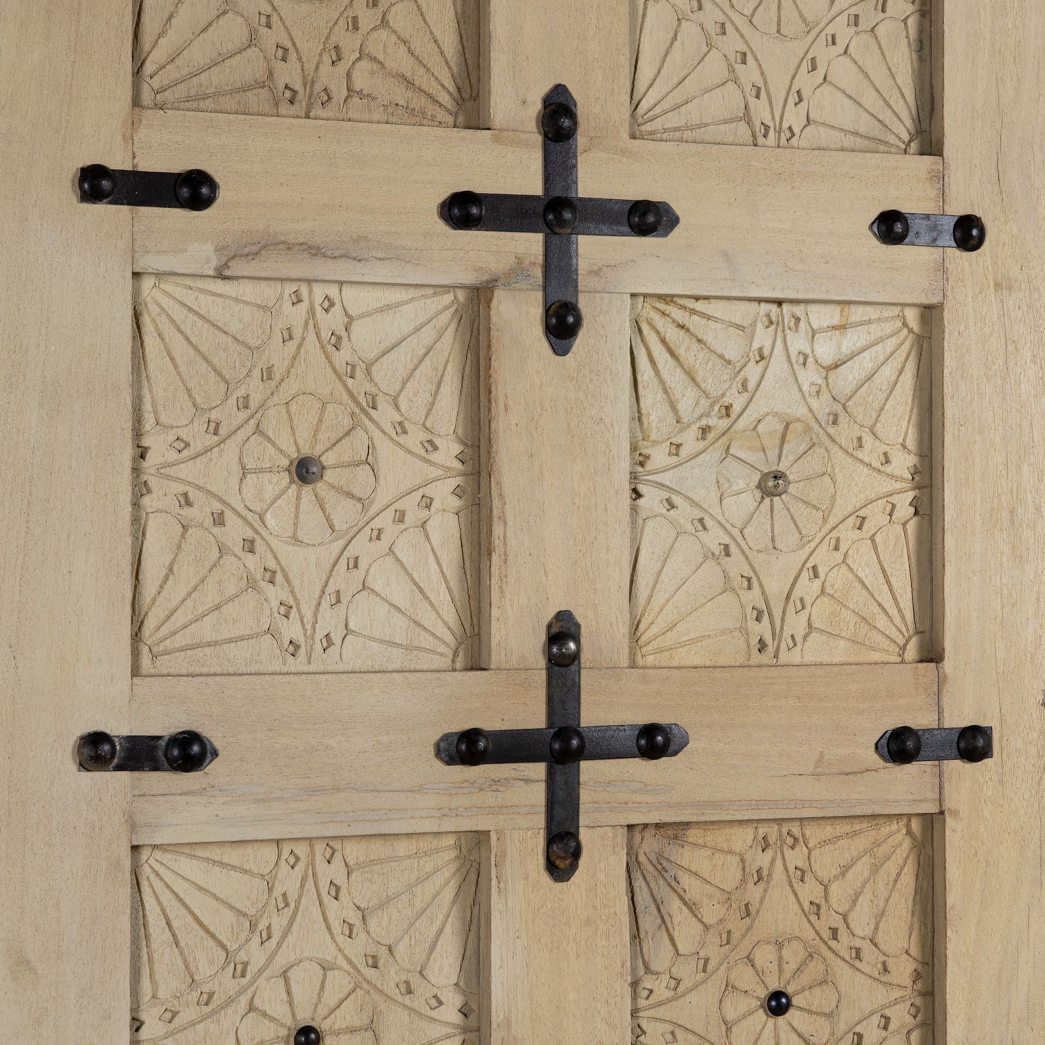 Wooden door with decorative patterns and metal hinges