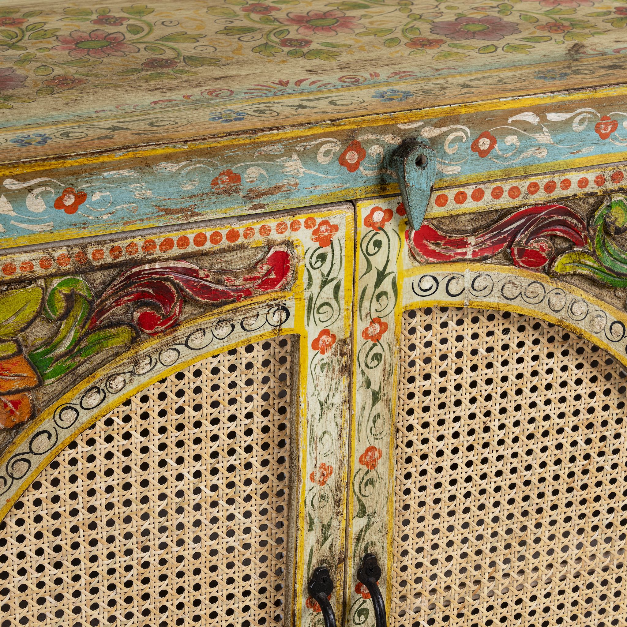 Close up image of a hand painted sideboard Ashara made of mango wood with rattan inserts; Ibiza-inspired boho chic furniture, 120 × 40 × 92 cm.