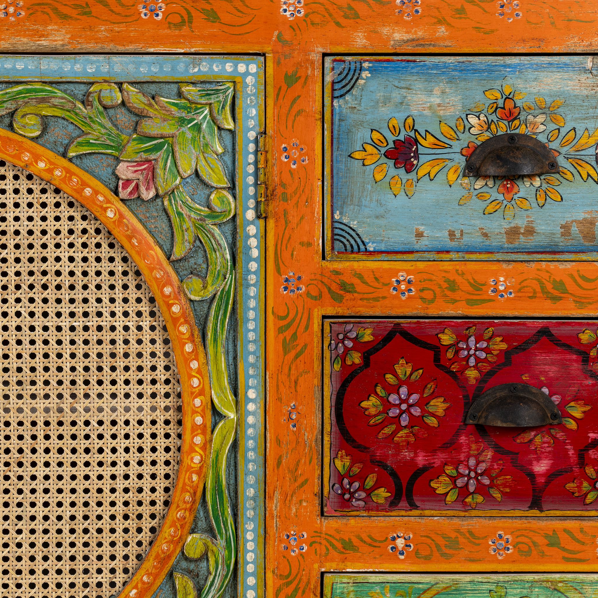 Close up image of a vintage style furniture sideboard with hand-painted floral motifs and rattan door inserts, bohemian rattan door furniture, 160 × 40 × 90 cm.