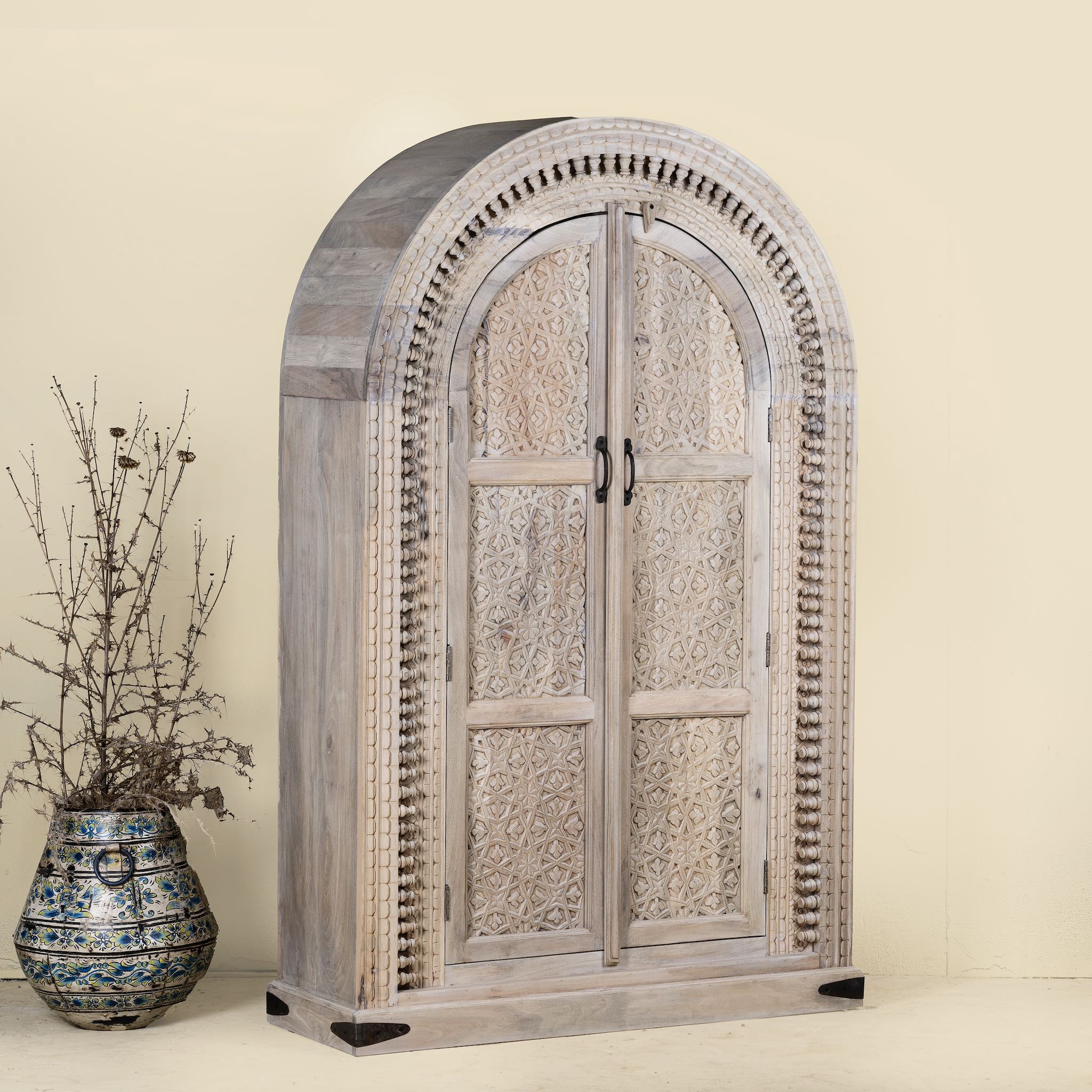 Side angle image of Ashwin wardrobe with arched carved doors, a unique furniture design from our mango wood furniture collection.