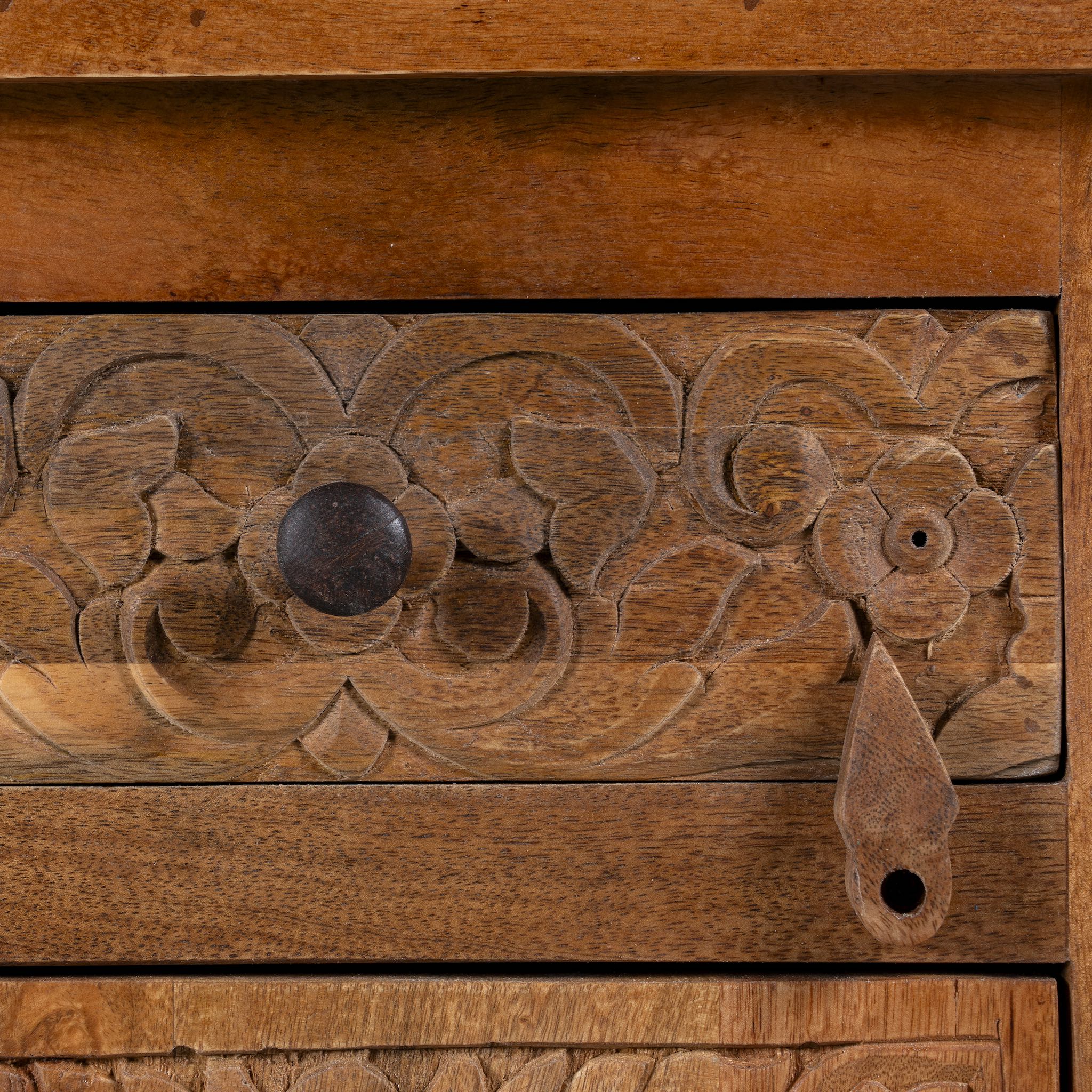 Close up image of a hand-carved mango wood bedside tables with floral motifs – a set of carved wooden furniture perfect for rustic and relaxed interiors.
