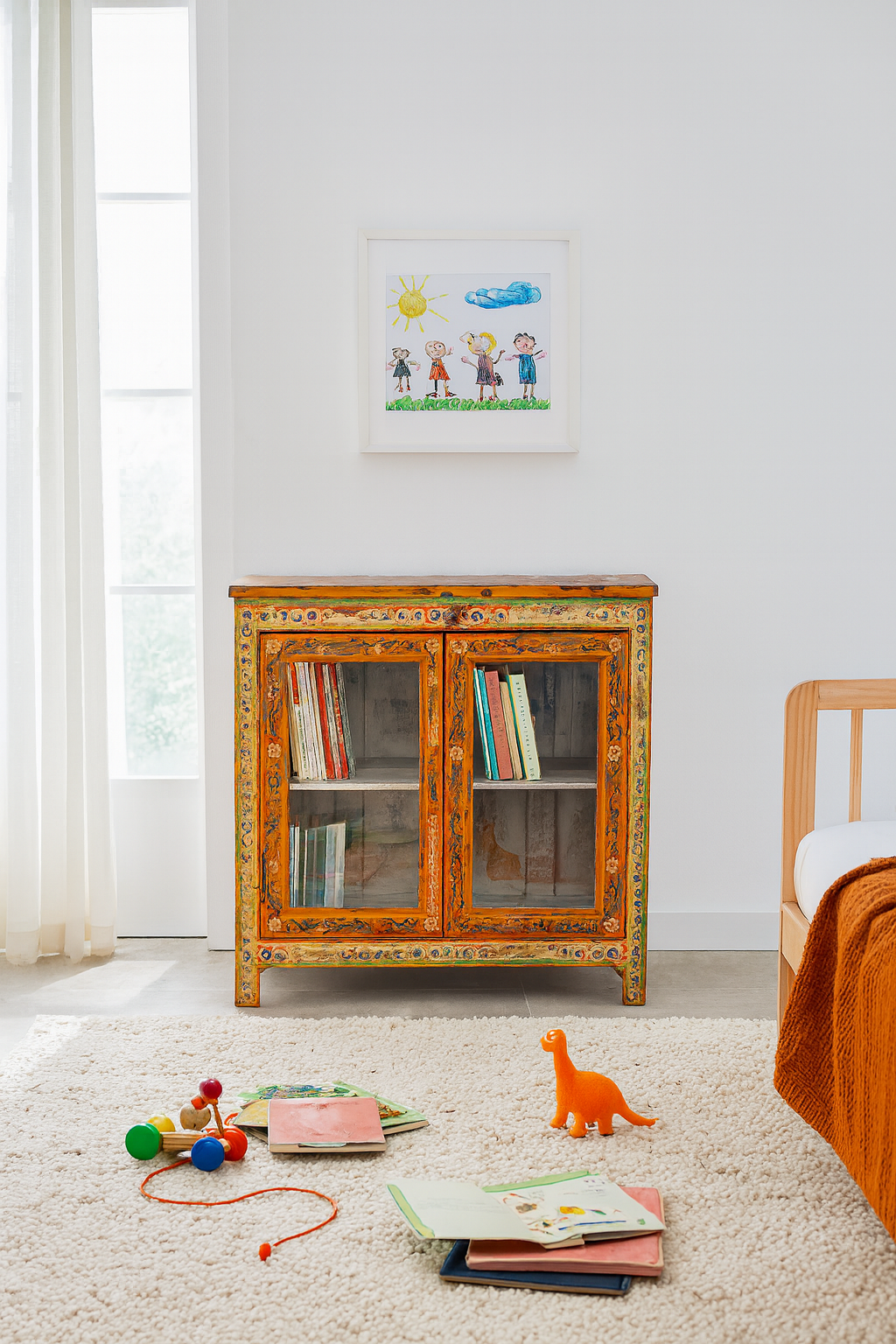 Lifestyle image of a hand-painted teak wood display cabinet with glass doors and vibrant Indian motifs – sustainable furniture with vintage charm and artisanal detail.