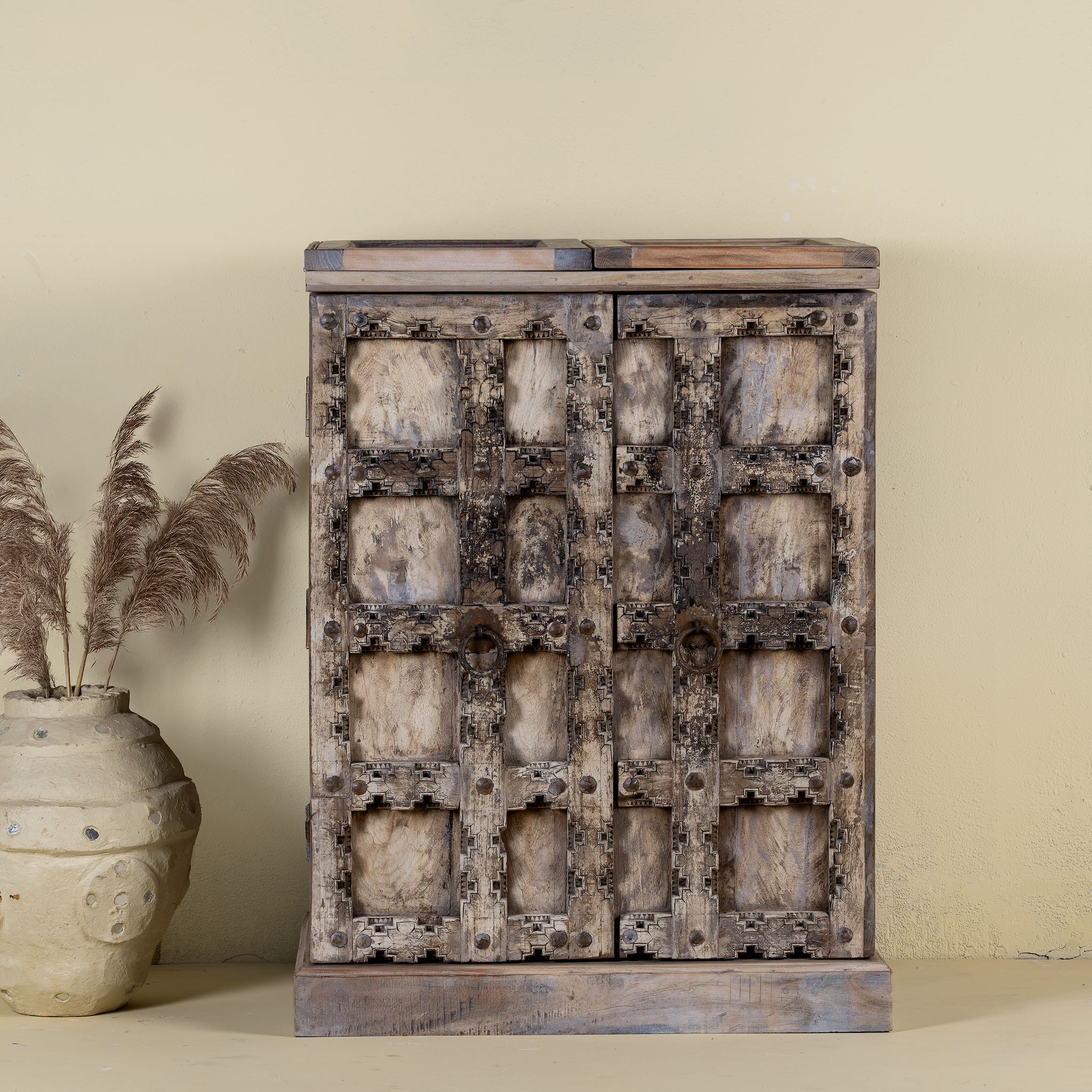 Foldable bar table made of reclaimed teak wood with inside storage and old door front.