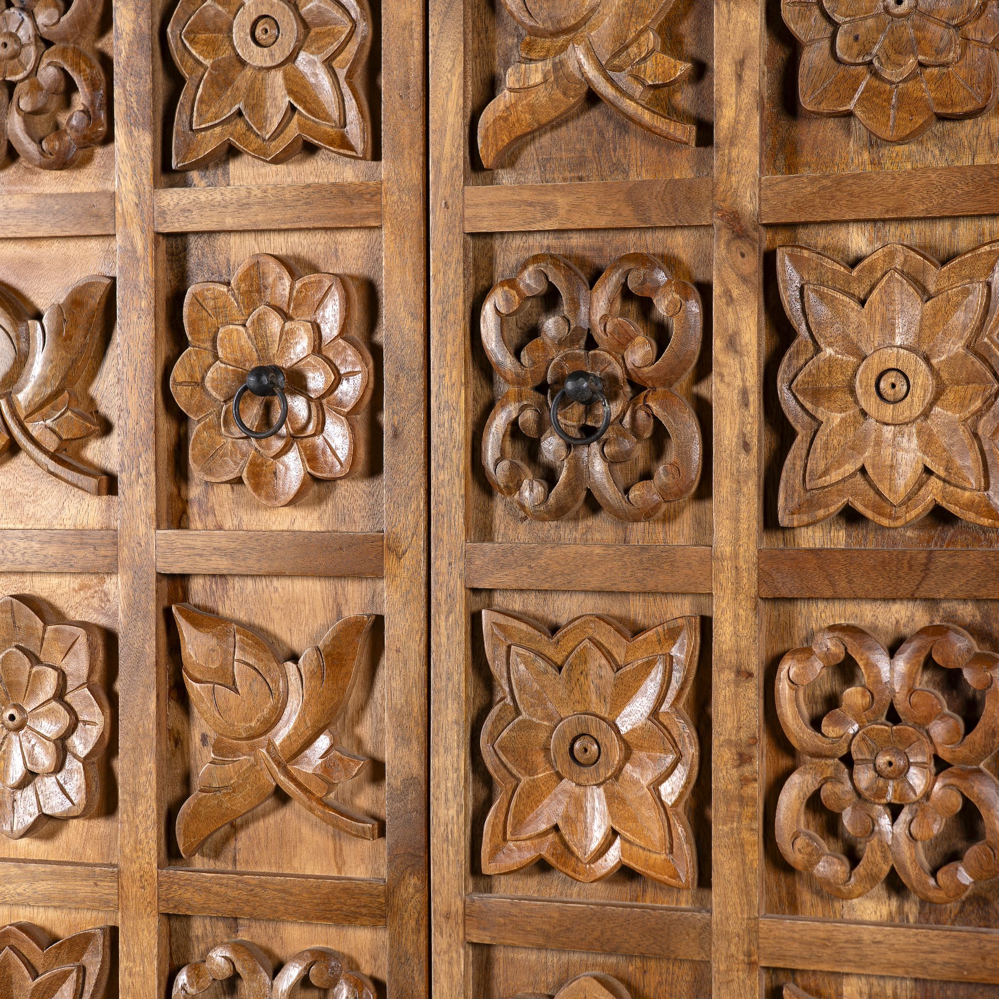 Close up image of a hand-carved mango wood wardrobe with floral motifs; wooden wardrobe in natural finish, 100 × 45 × 190 cm.