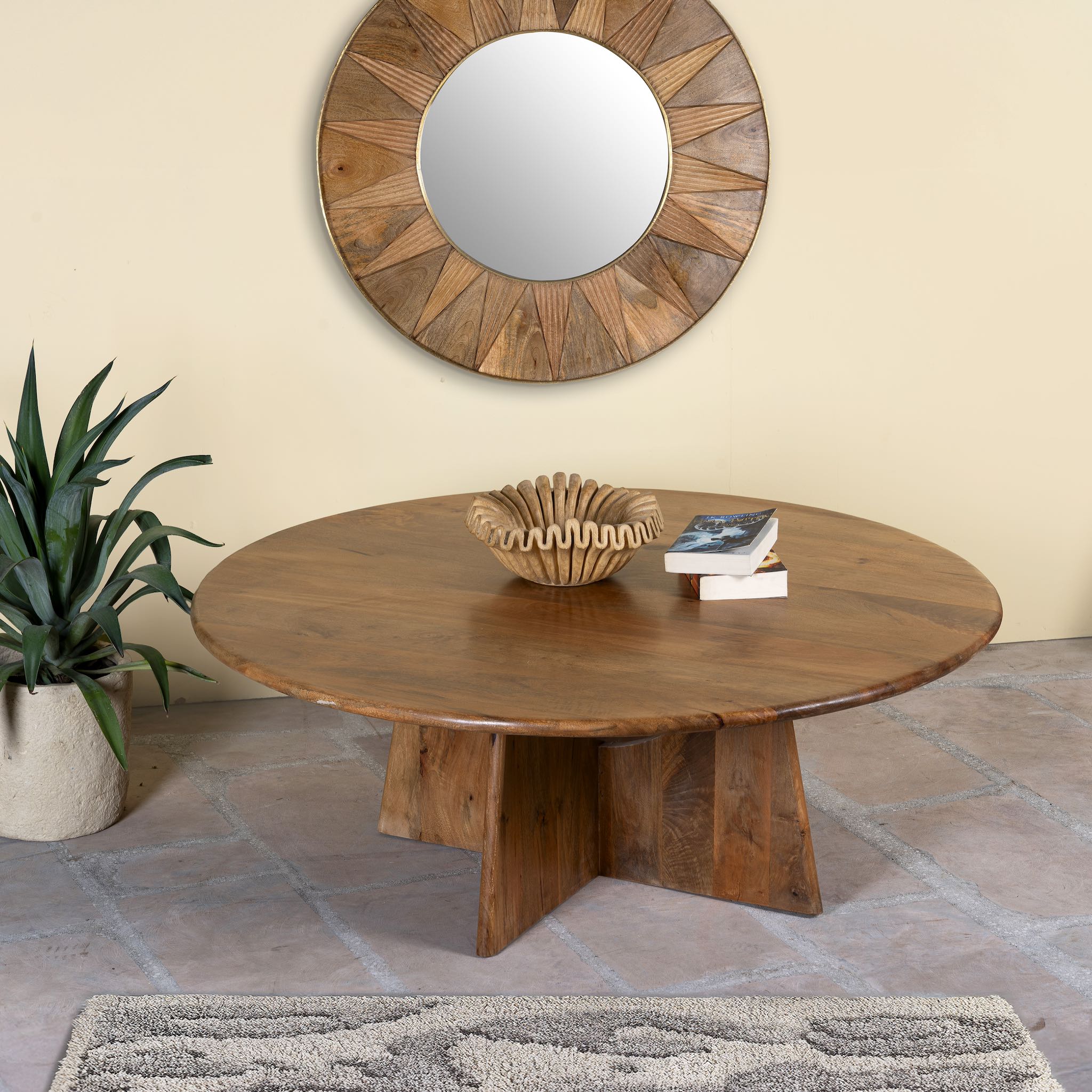 Side angle image of a round mango wood coffee table with rustic finish and cross-base design, Dia 120 × H 45 cm, living room furniture.