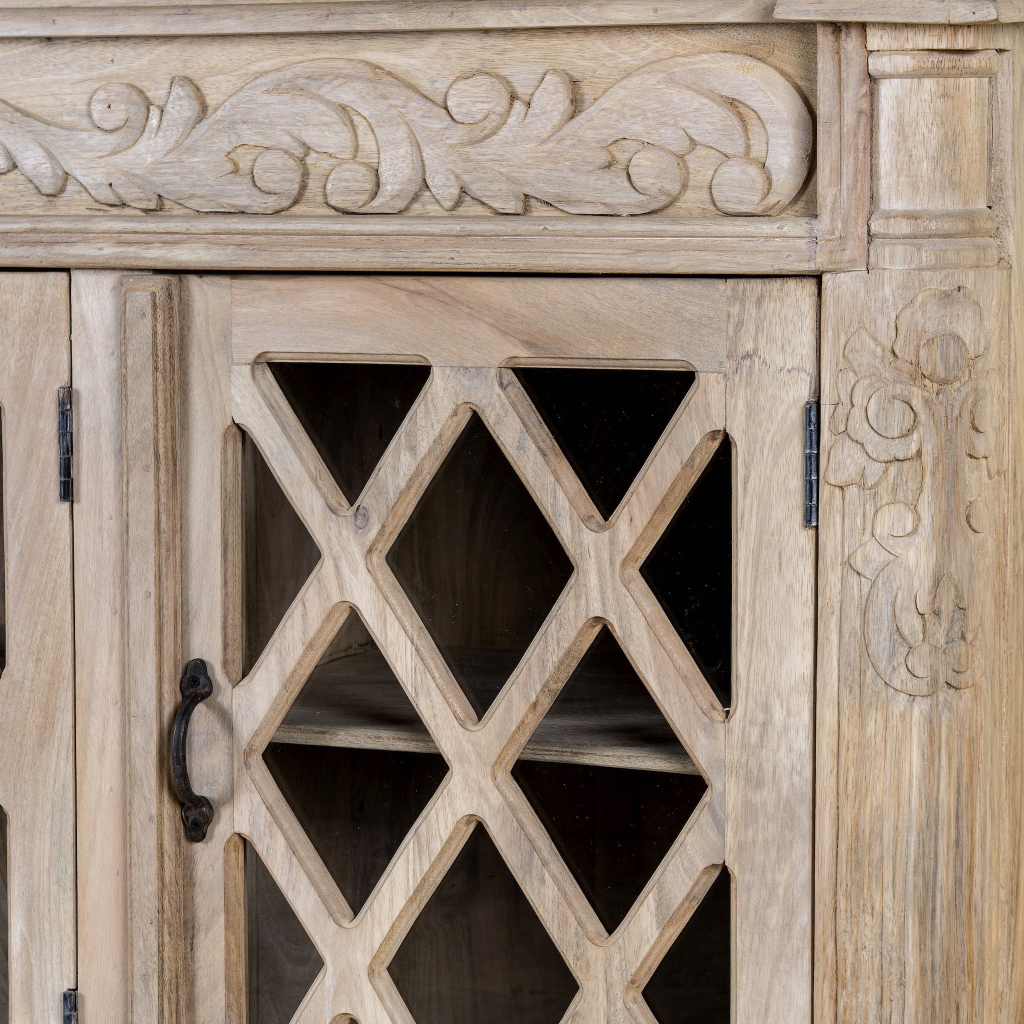 Rustic sideboard made of Mango wood with hand-carved details and glass panelled doors featuring a diamond lattice design.