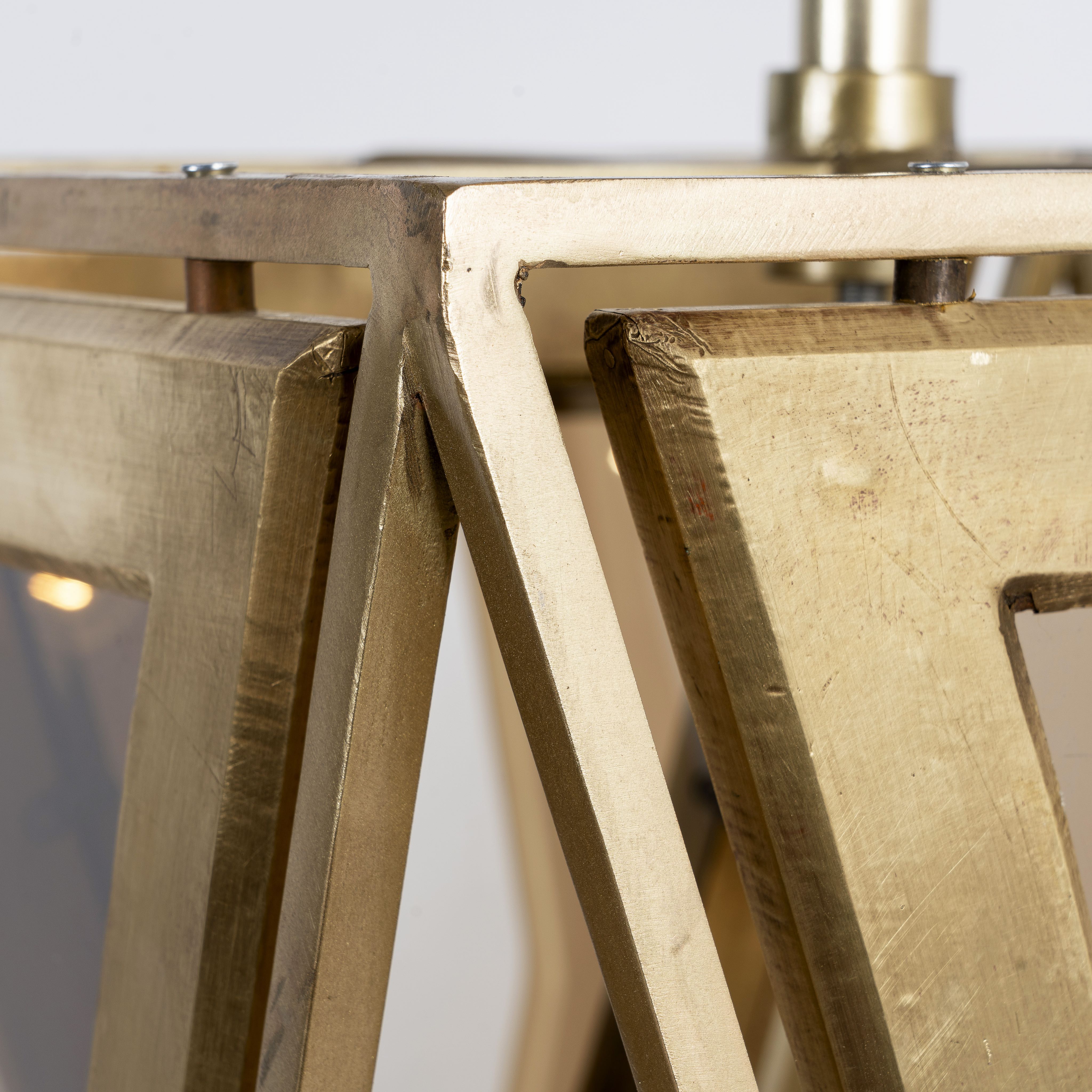 Close up image of a tapered pendant lamp with wood, brass cladding, and tinted glass panels – vintage lighting meets modern design, ideal for use as an iron pendant lamp in living rooms, dining areas, or entryways.