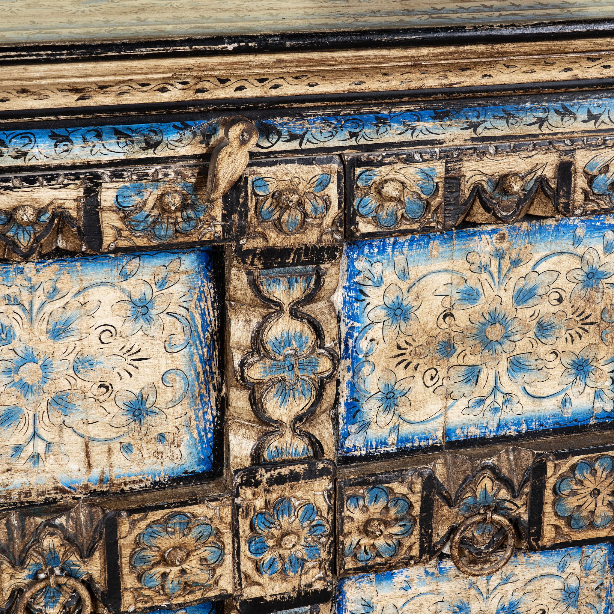 Close up image of a cupboard made from an antique Indian old door, hand painted cabinet with blue floral details; boho style teak wood furniture, 115 × 50 × 104 cm.