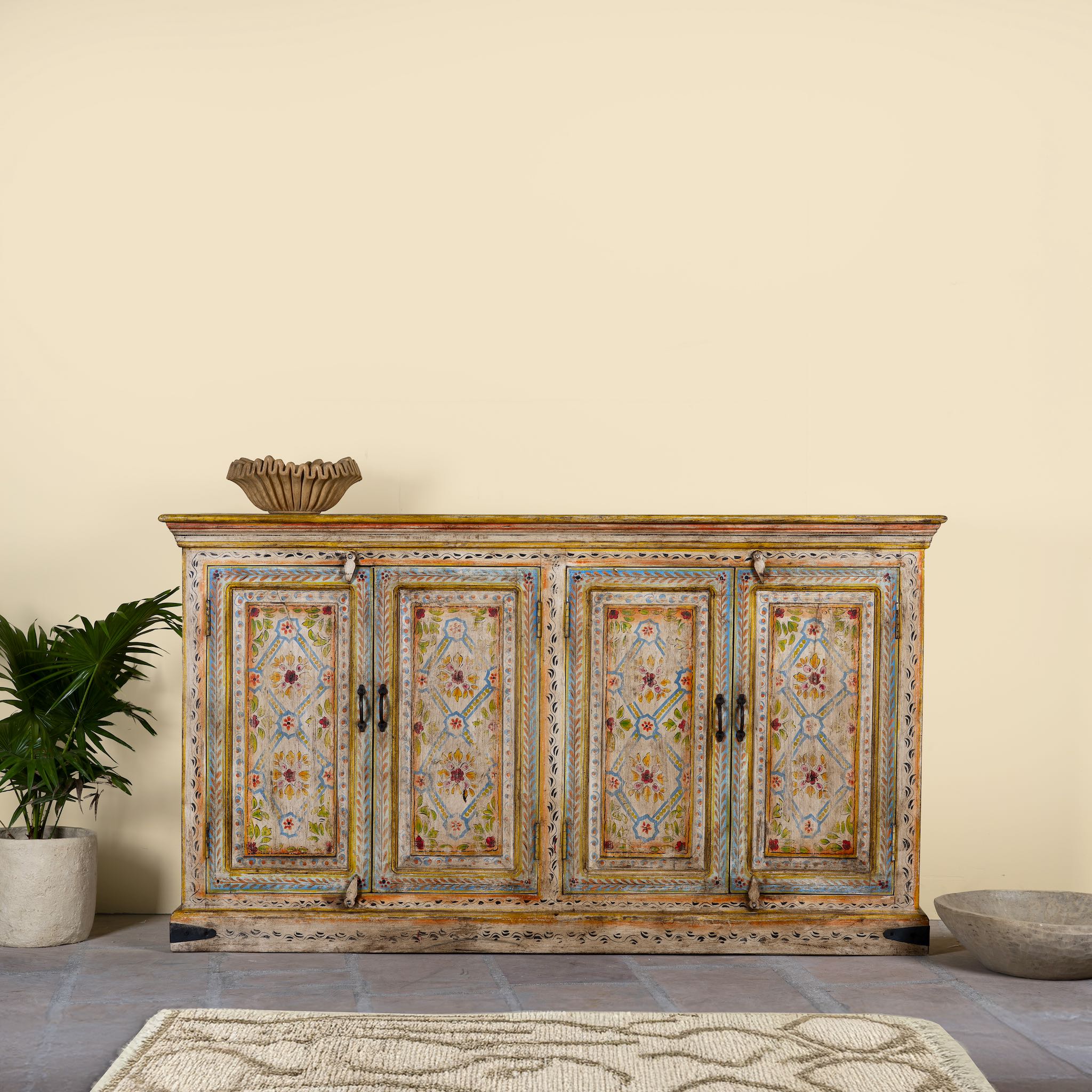 Hand-painted reclaimed wood sideboard with floral motifs, a bold piece of vintage furniture for living room furniture collections.