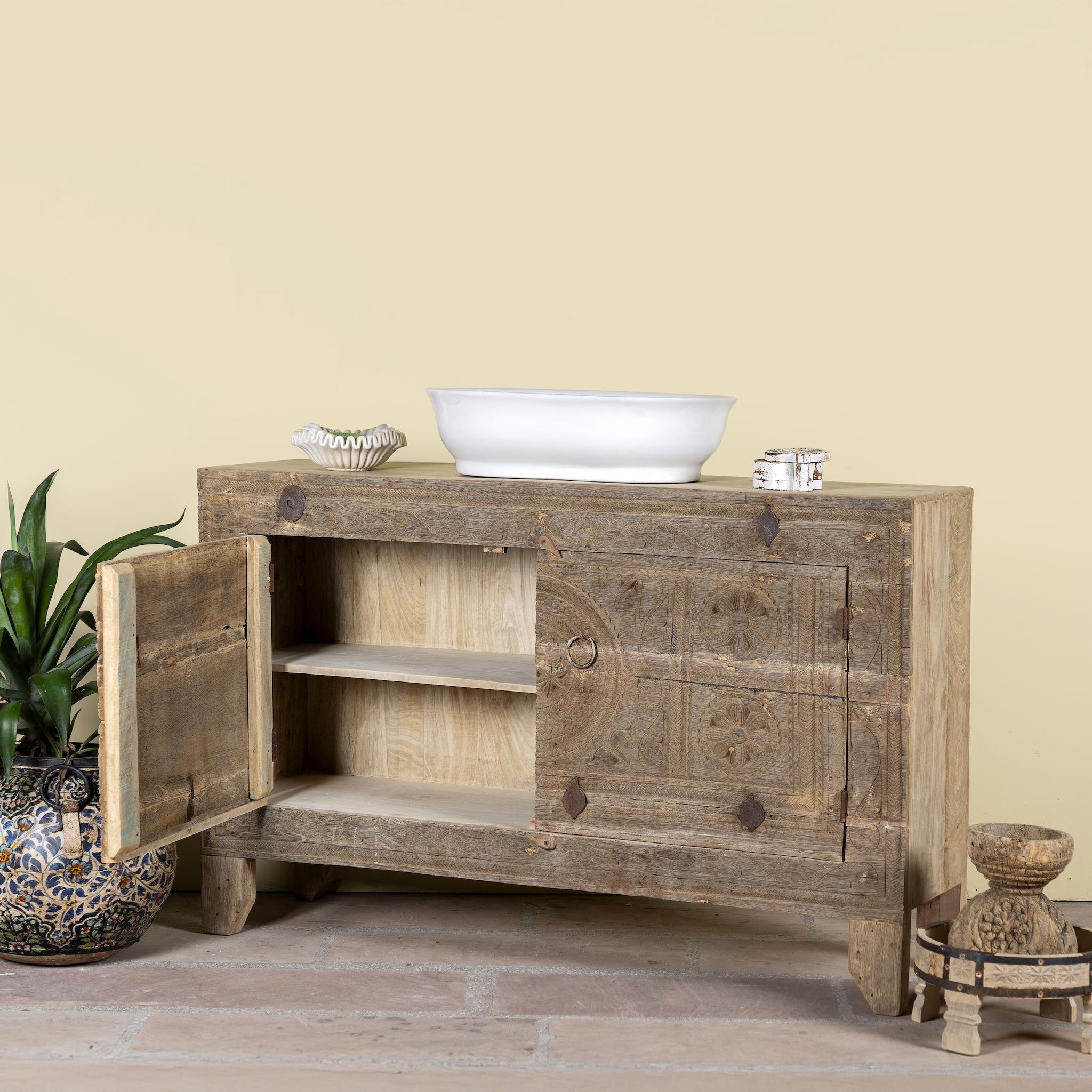 Side angle image with open door of Etasha, a reclaimed wood sideboard made from antique teak doors with carved detailing; teak furniture, 130 × 38 × 83 cm.