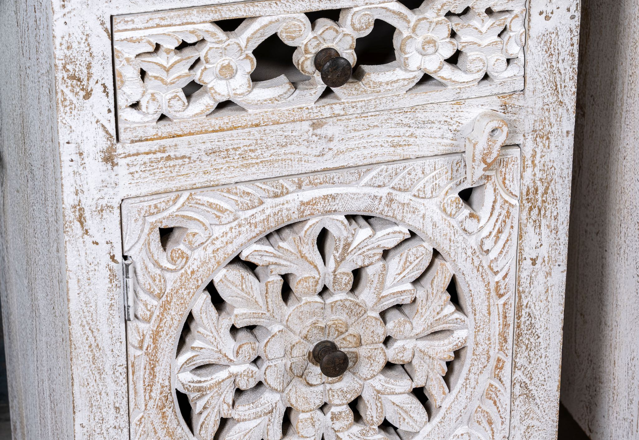 Close up image of a whitewashed nightstand made of mango wood with Mediterranean-style carved detailing and one drawer – Gagan bedside table by Om Home & Garden