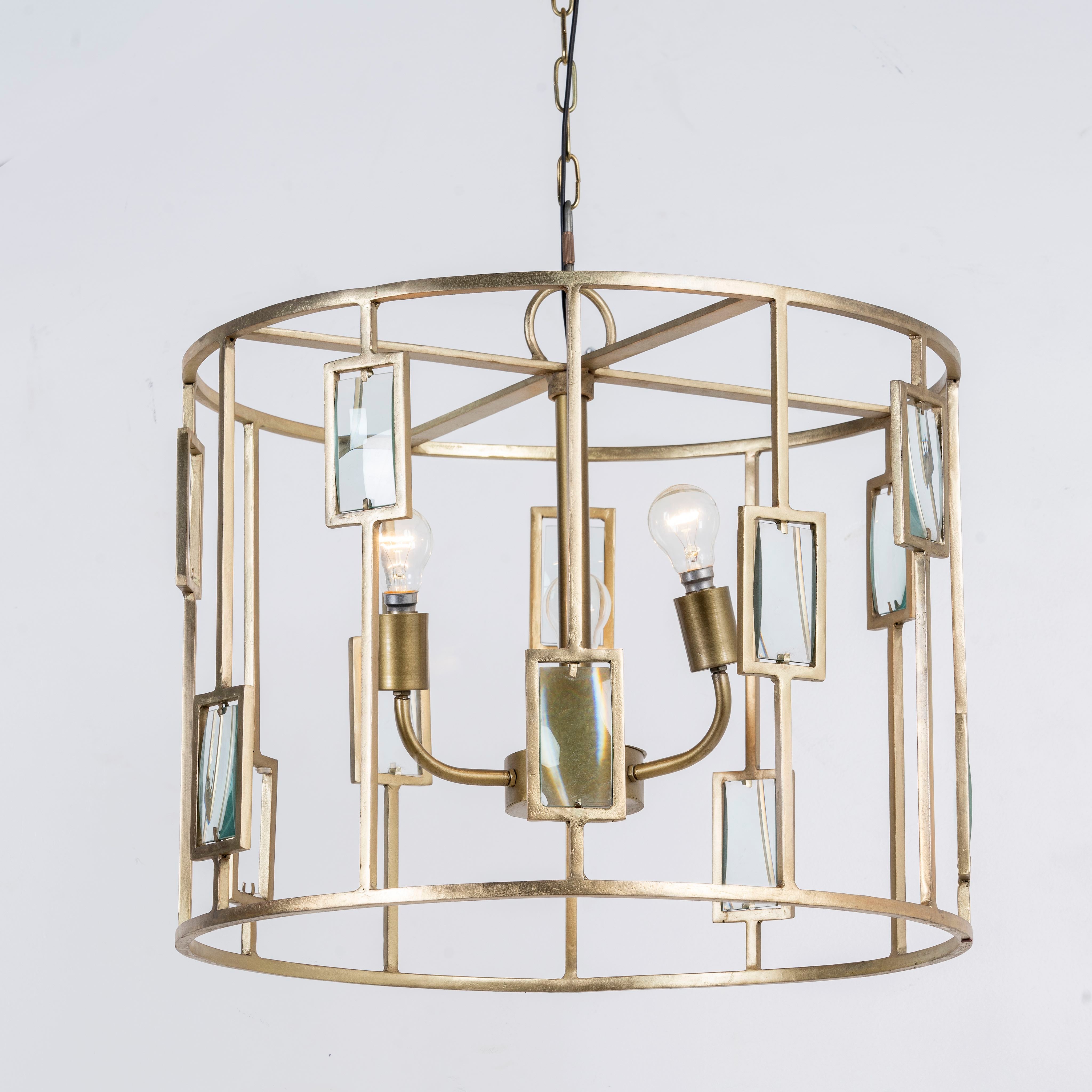 Side angle image of a unique pendant light with round shiny brass-plated frame and magnifying glass inserts – vintage lighting with three-light design for dining rooms, kitchens, or elegant interiors.