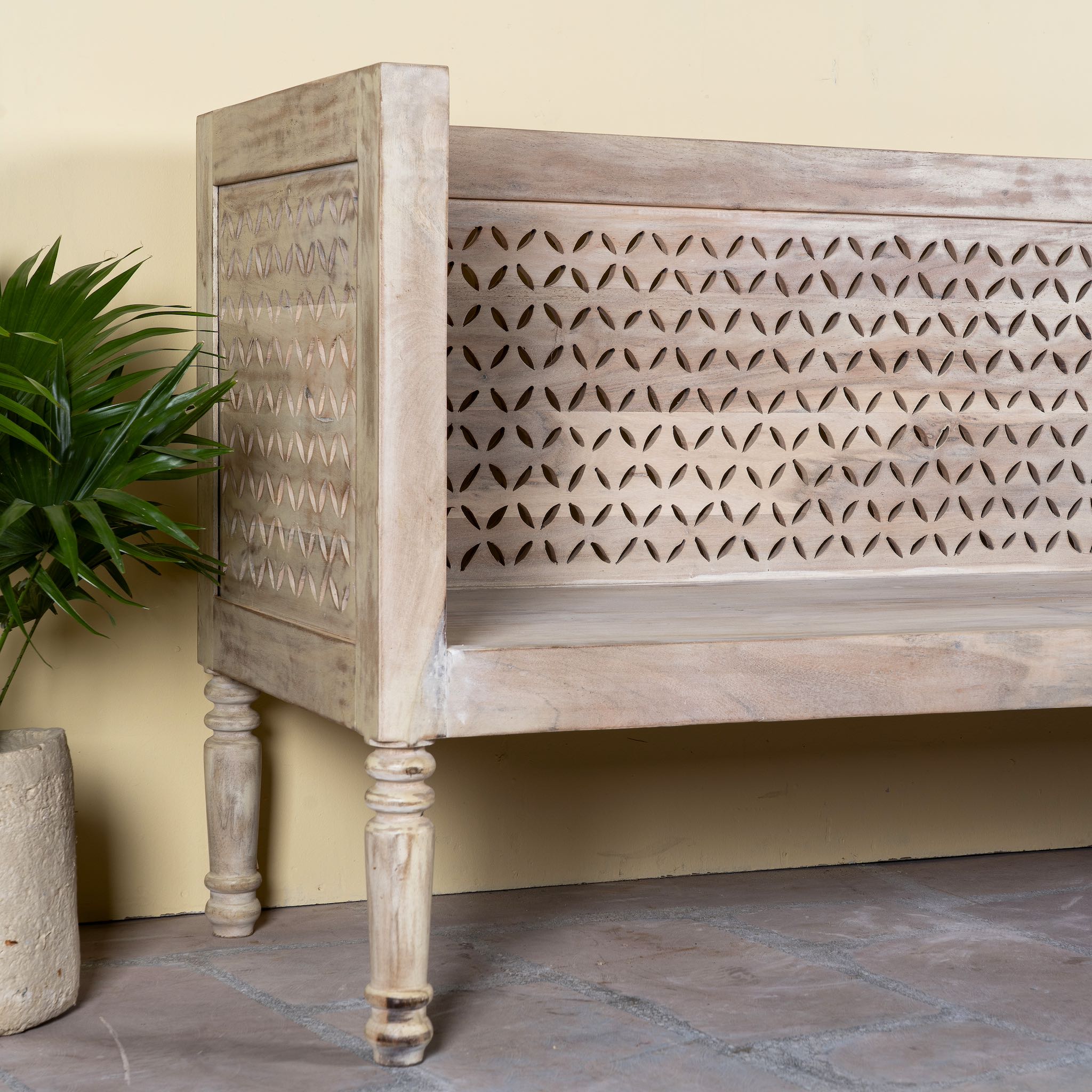 Close up image of a hand-carved reclaimed wood bench with geometric backrest design, sandblasted Ibiza style finish, ideal for boho chic living room interiors, 176×56×95 cm.