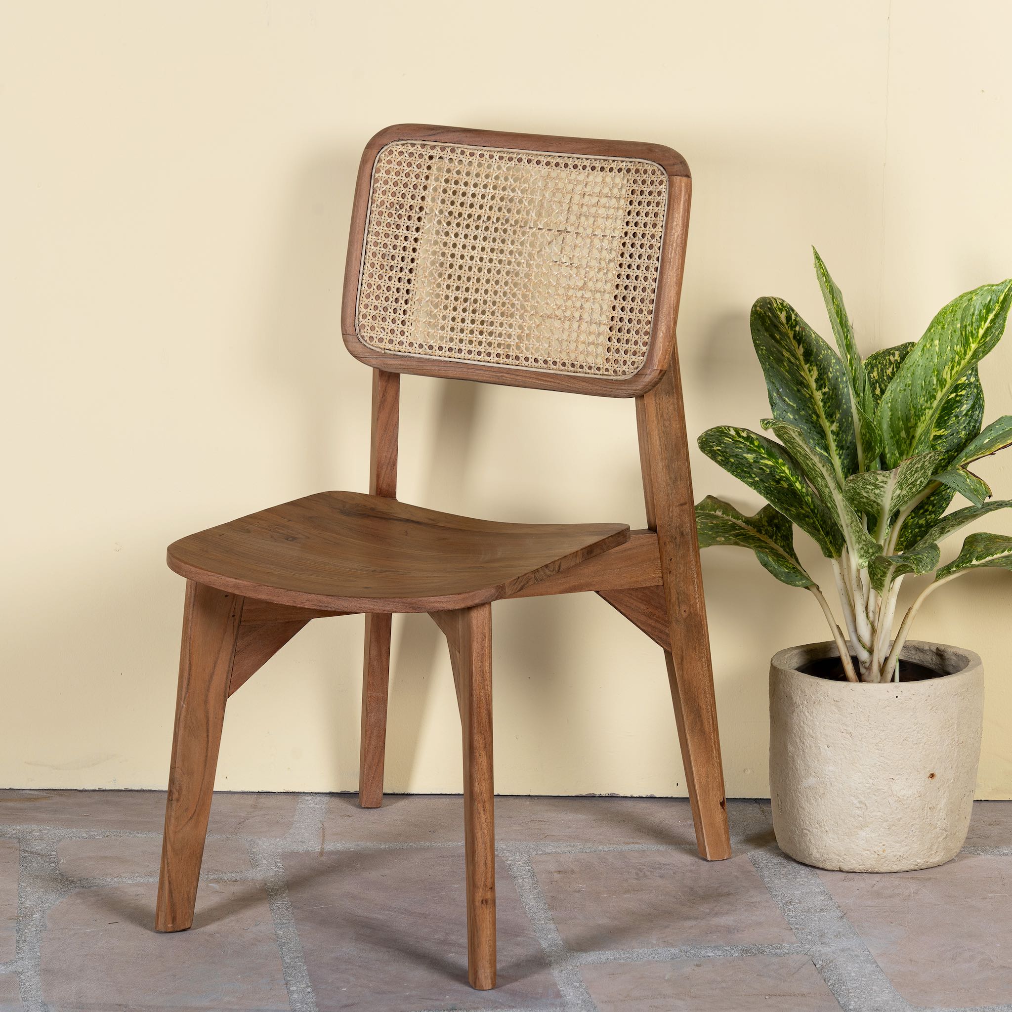 Side angle image of an acacia wood chair with woven rattan backrest and solid wooden frame; wooden armchair for dining or living rooms, 45 × 45 × 85 cm.