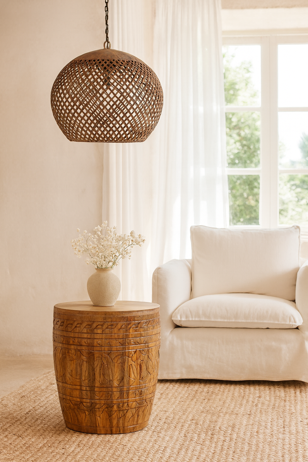 Lifestyle imagination of a hand-carved mango wood coffee table with barrel shape and warm rustic finish; vintage style coffee table, 45 cm diameter, 55 cm height.