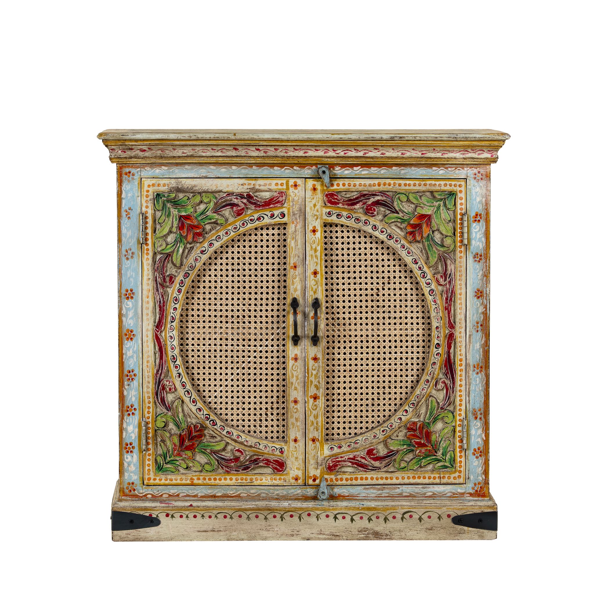 White background image of a hand-painted, hand-carved cupboard made of mango wood with floral design and rattan inserts.