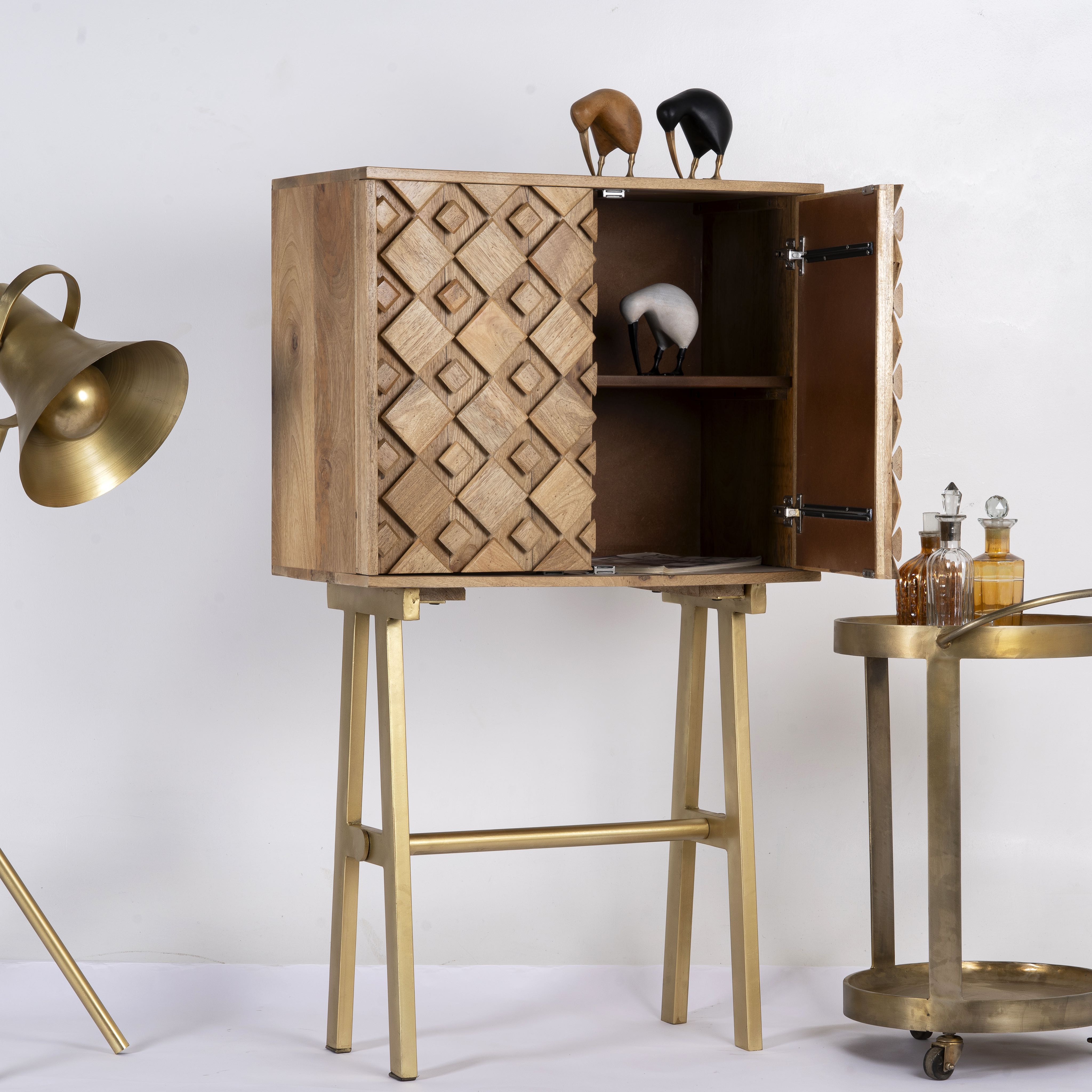 Side angle image with open door of a Tall mango wood cabinet in grey sandblasted finish with geometric sunburst design and brass handles, 76 × 38 × 135 cm.