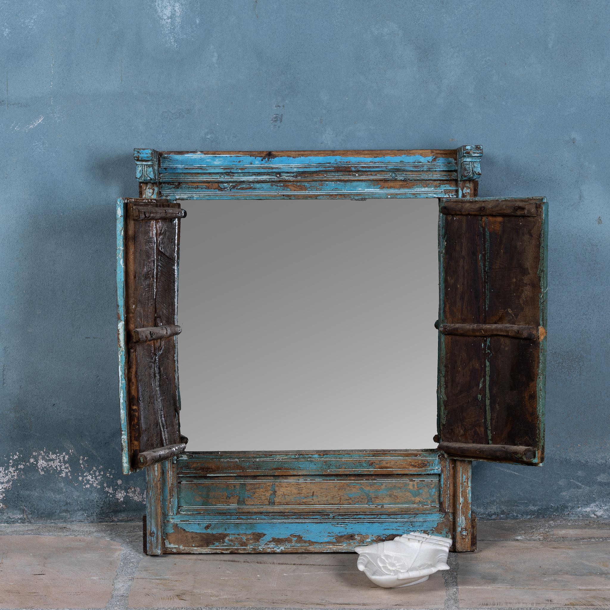 Open shutter image of an antique teak window mirror with blue paint and shutters, vintage wall panel design from our vintage home accessories range.