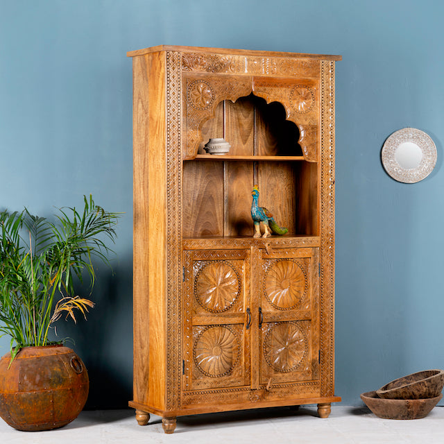 Side angle image of a hand-carved mango wood shelf with floral detailing, open shelf, and carved legs – carved wooden furniture in honey finish for rustic and Mediterranean interiors.