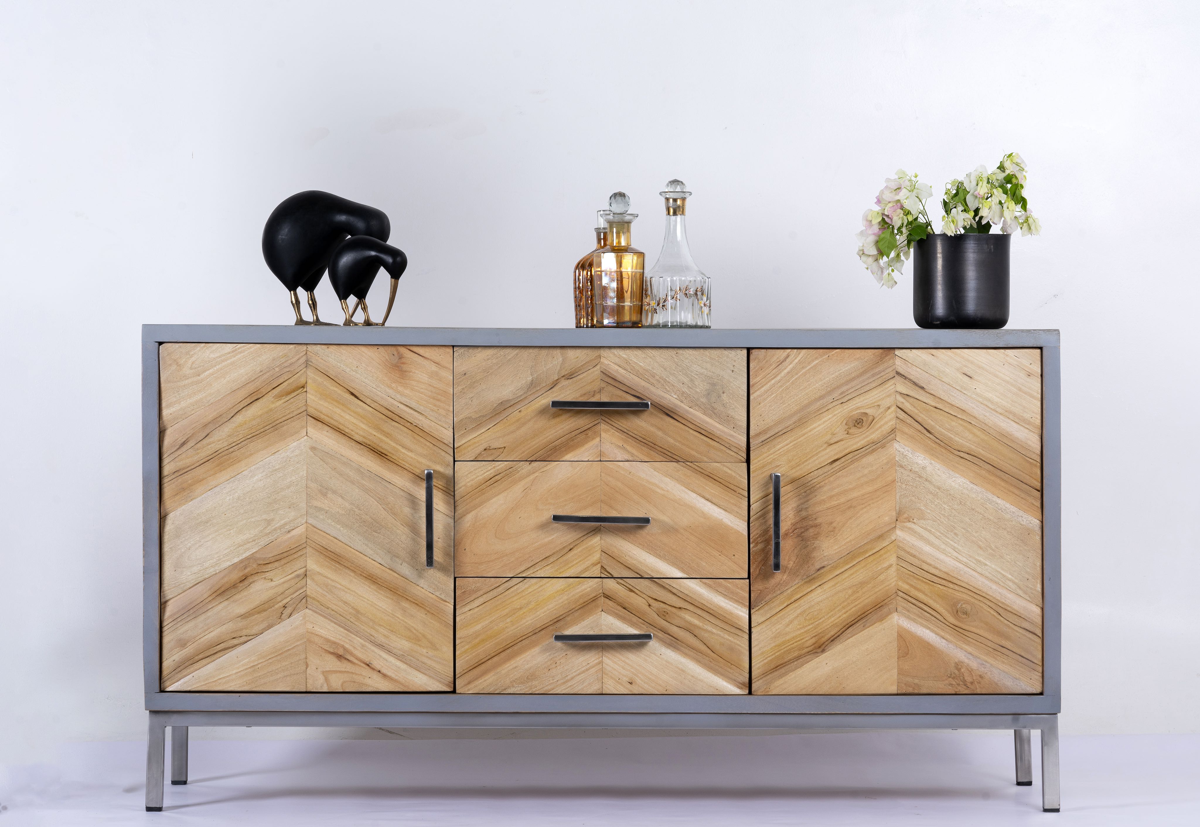 Handcrafted teak wood sideboard with parquet design and grey stainless steel frame—artisanal furniture ideal for a modern living room.