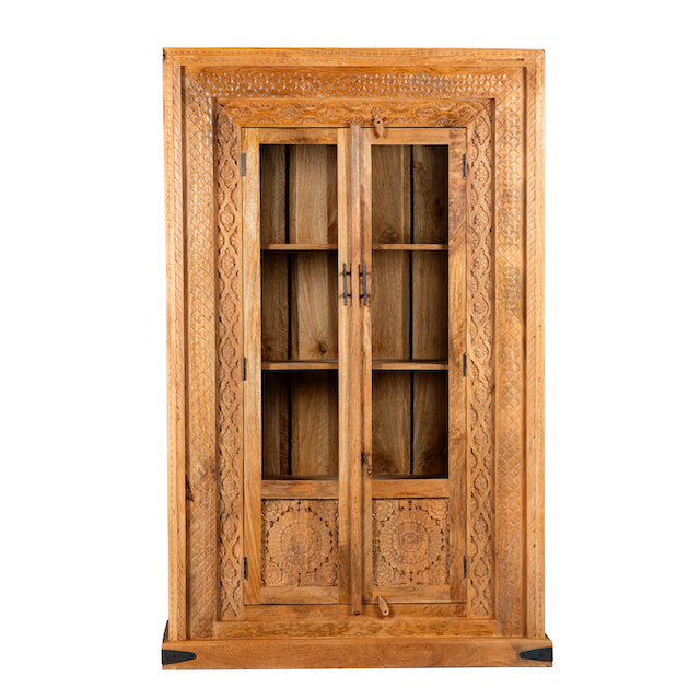 White background image of a hand carved display cabinet made from natural mango wood with floral detailing and glass-panelled doors; 180 × 110 × 40 cm.