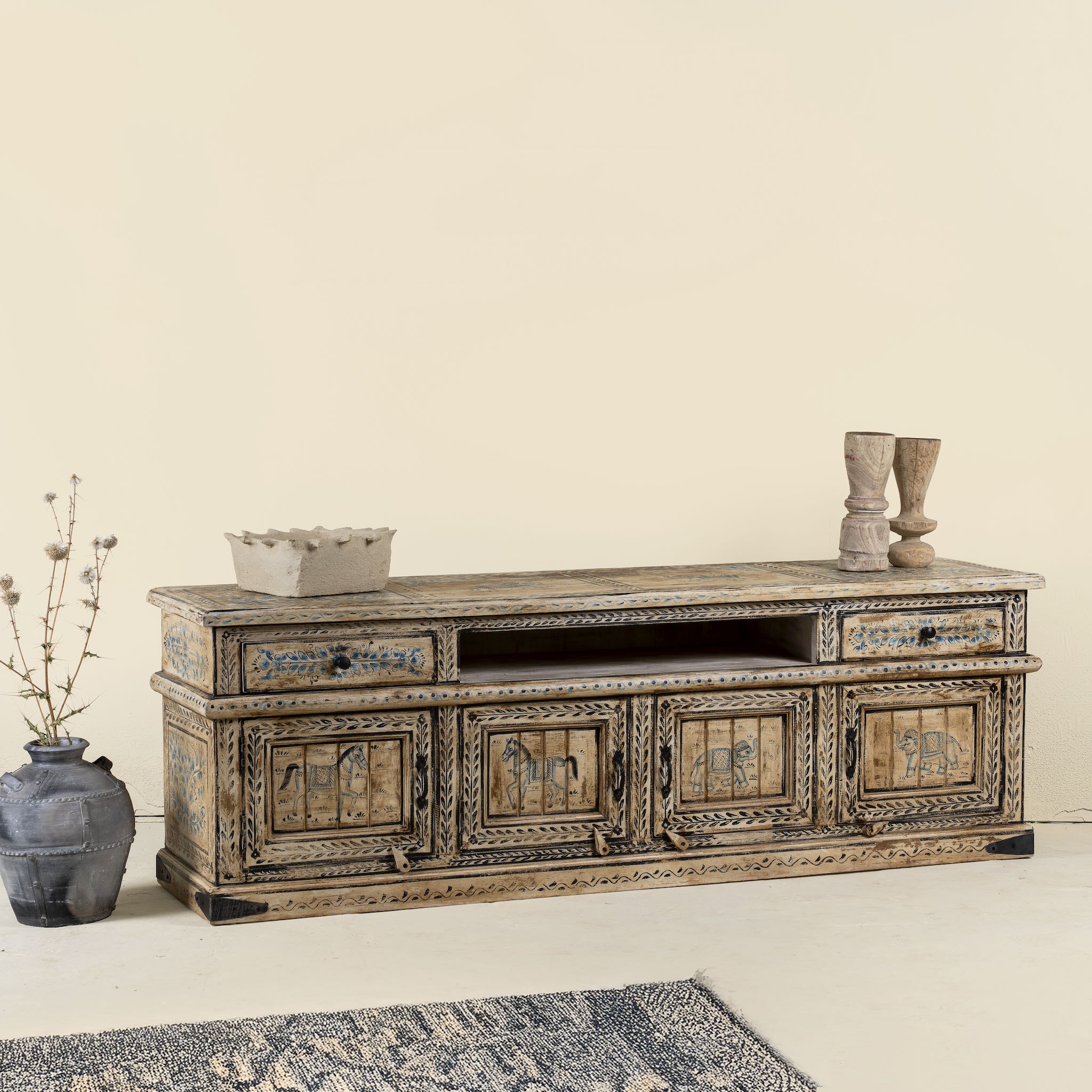 Side angle image of a hand painted TV unit in reclaimed wood with Indian elephant and horse motifs, drawers and cabinets, 180 × 45 × 60 cm.