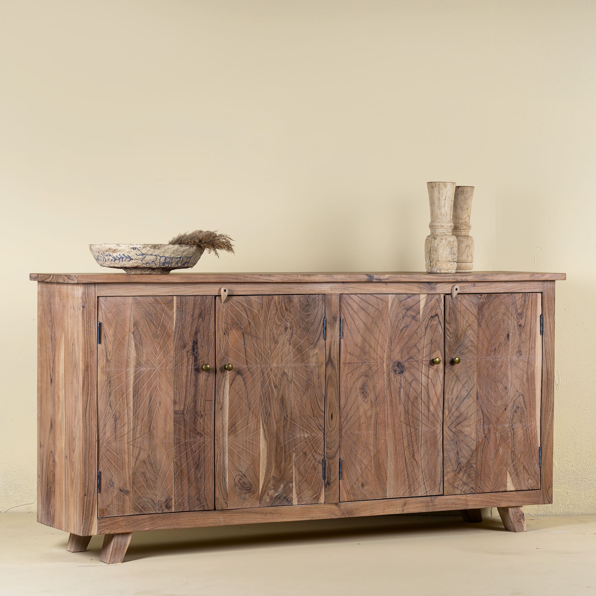 Side view of a sideboard with modern appeal made of acacia wood with brass fitted doorknobs and 4 doors.