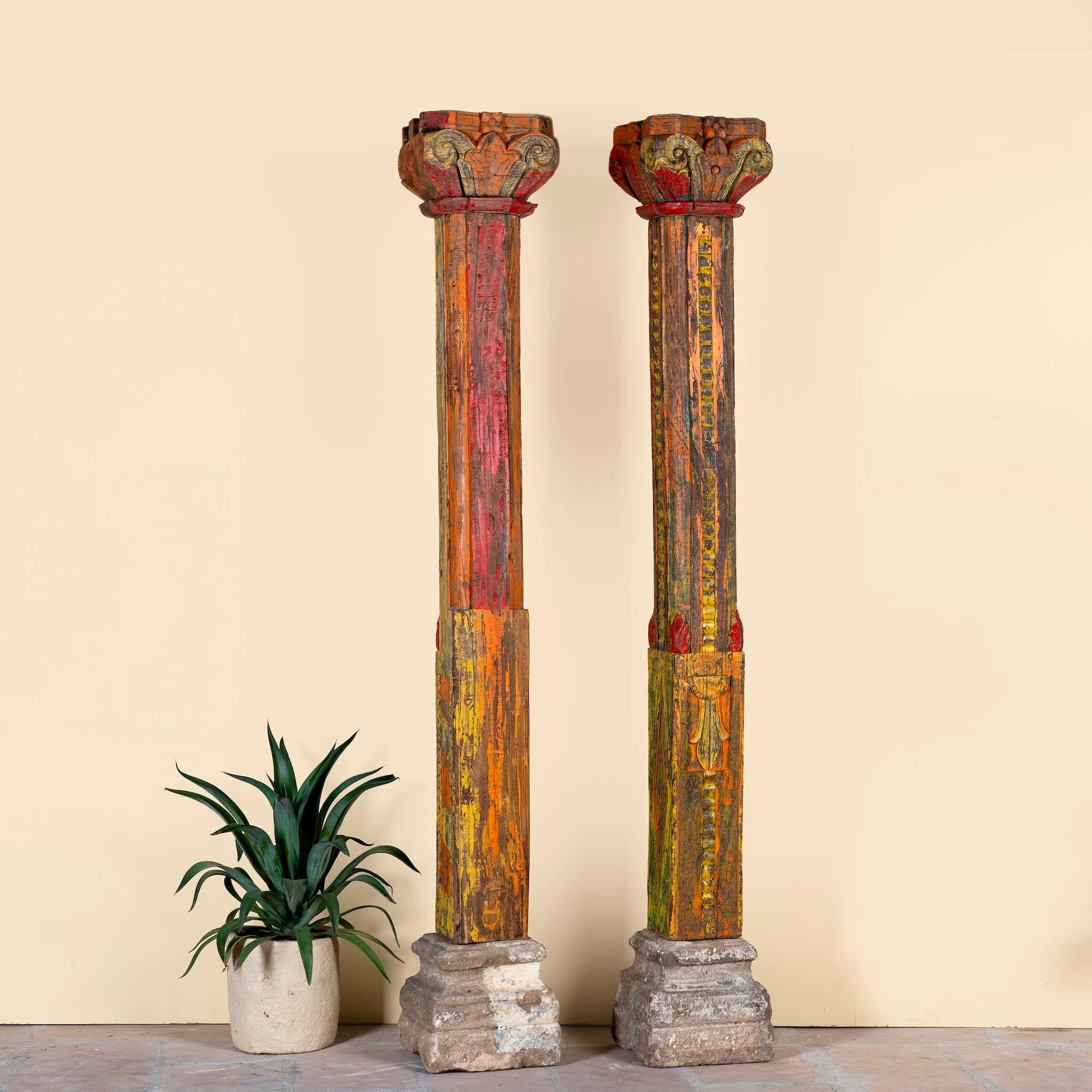 Antique pair of carved wooden house pillars with original stone bases, weathered multicolour finish, 210 cm high, vintage home decor and boho chic living room accents.