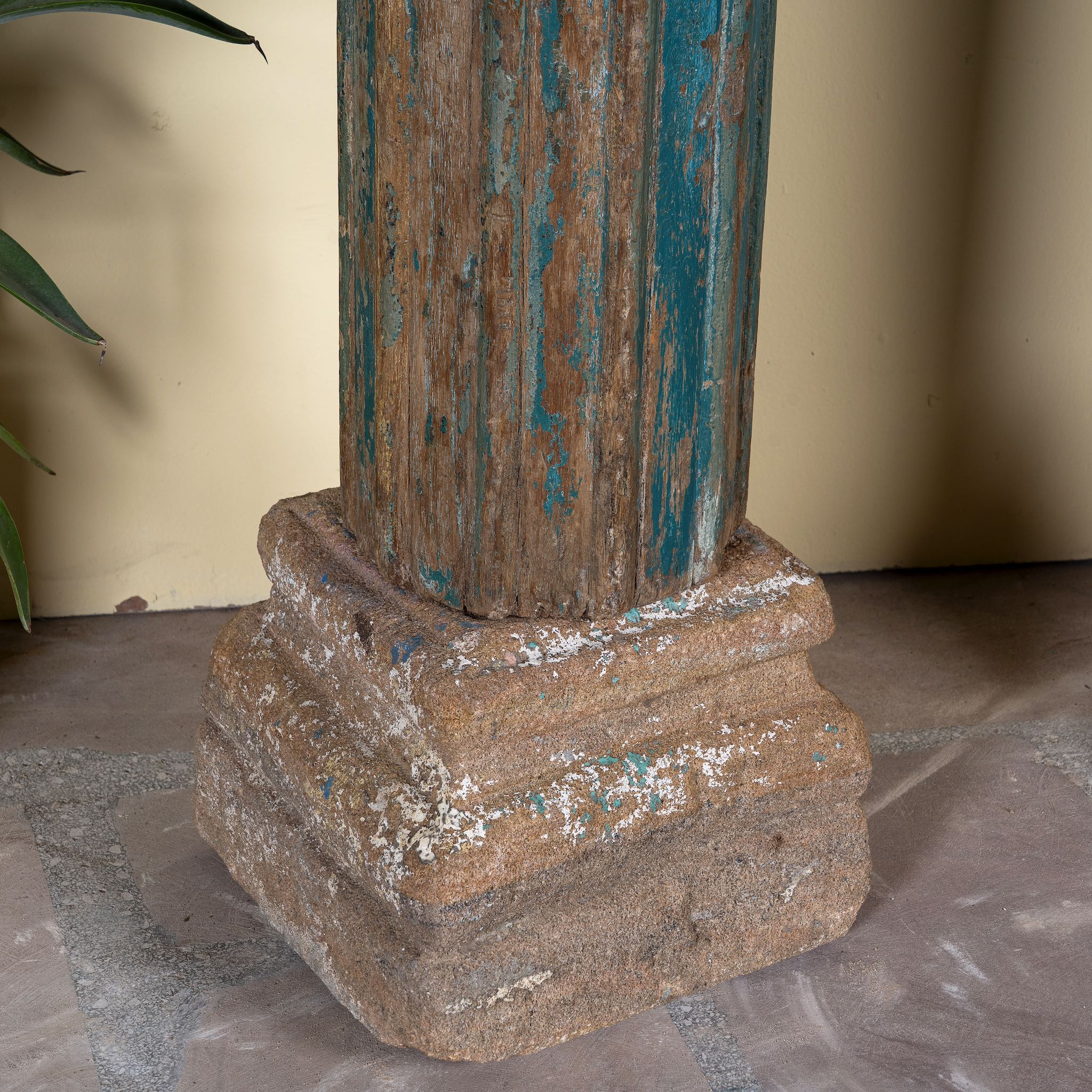 Close up image of the stone base of an antique pair of carved wooden house pillars with original stone bases, weathered multicolour finish, 210 cm high, vintage home decor and boho chic living room accents.