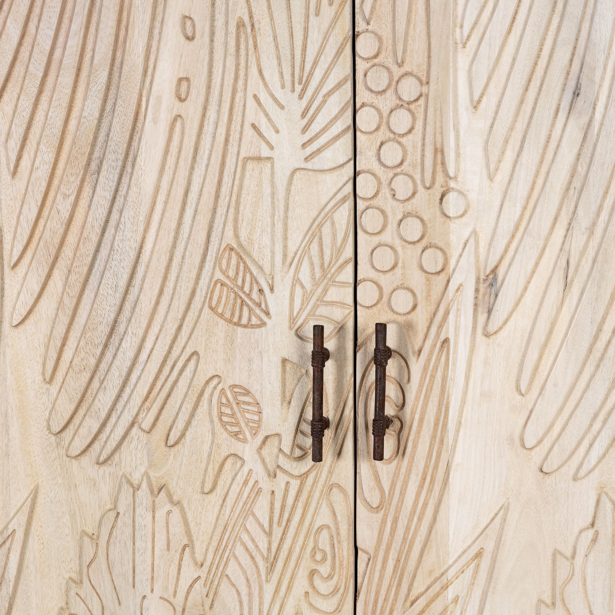 Close up image of a hand-carved mango wood wardrobe with sandblasted finish and iron stand; artisanal bedroom furniture, 90 × 46 × 183 cm.