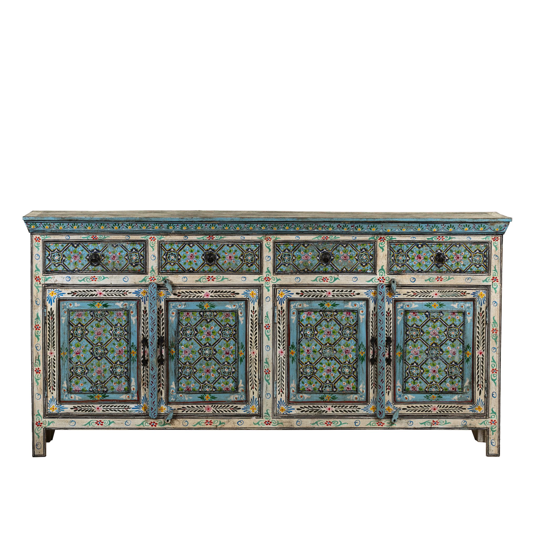 White background image of a hand-painted reclaimed wood sideboard with floral and geometric patterns in vibrant hues. The sideboard has multiple drawers and cabinet doors, and is placed in a room with a vase on top and a chair to the side.