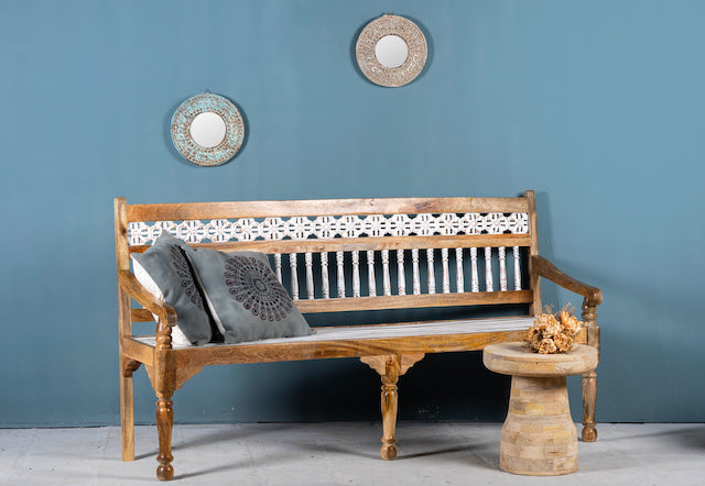 Side angle image of a hand carved mango wood bench with floral backrest and spindle accents; rustic mango wood seating, 176 × 56 × 95 cm.