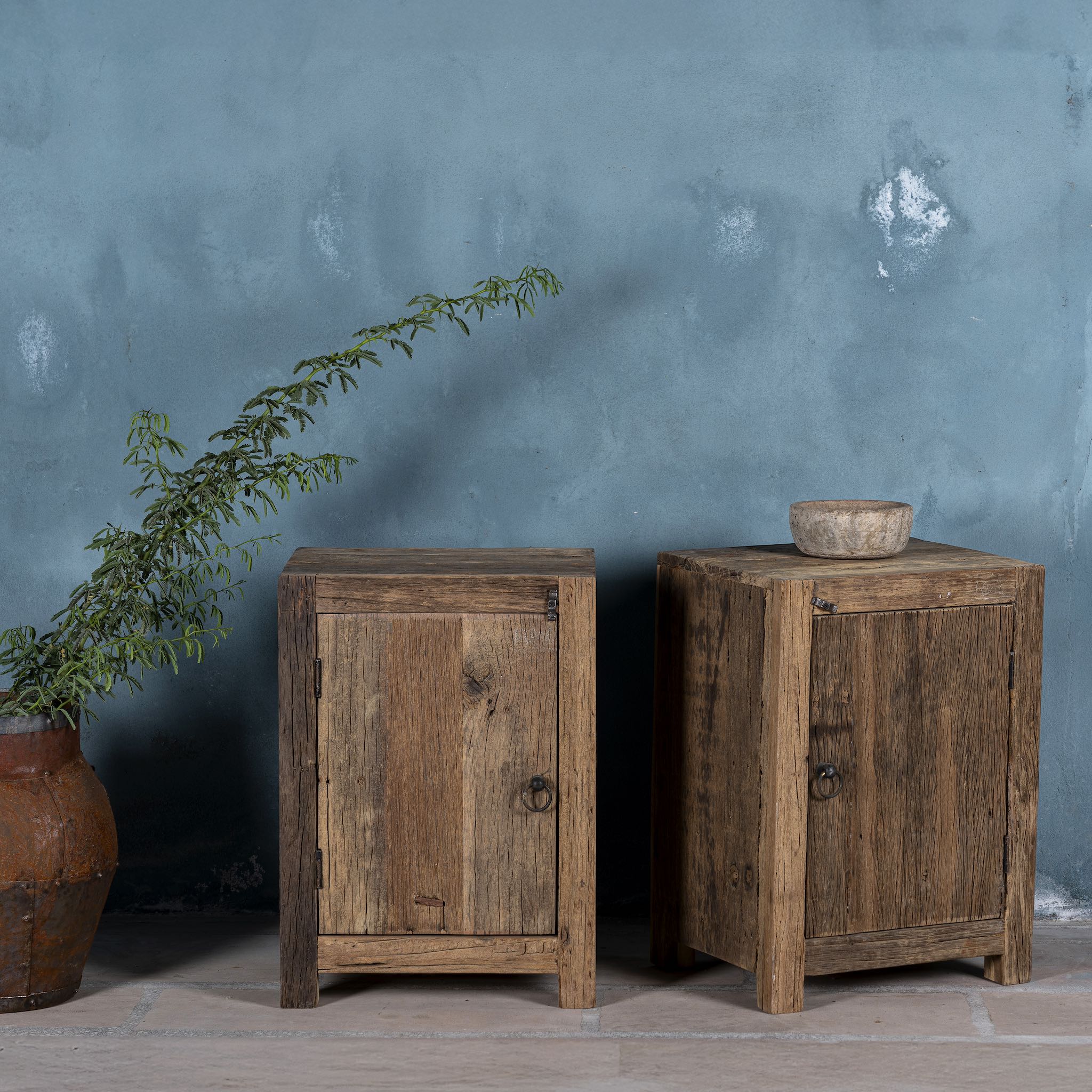 Side angle image of a reclaimed wood bedside table with single cabinet door – handcrafted driftwood furniture ideal for rustic minimalism and natural interior styling.