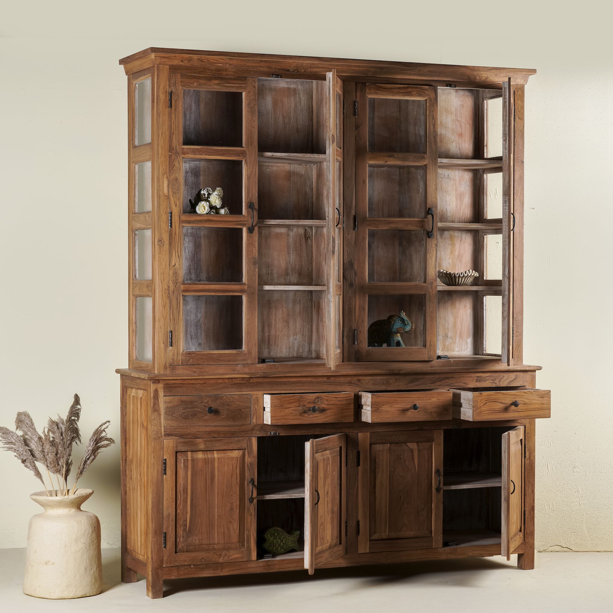 Open door image of a two-part showcase cabinet made from reclaimed teak wood, featuring glass-panel upper doors for display, four drawers for storage, and lower cabinets with solid wood doors in a natural finish.