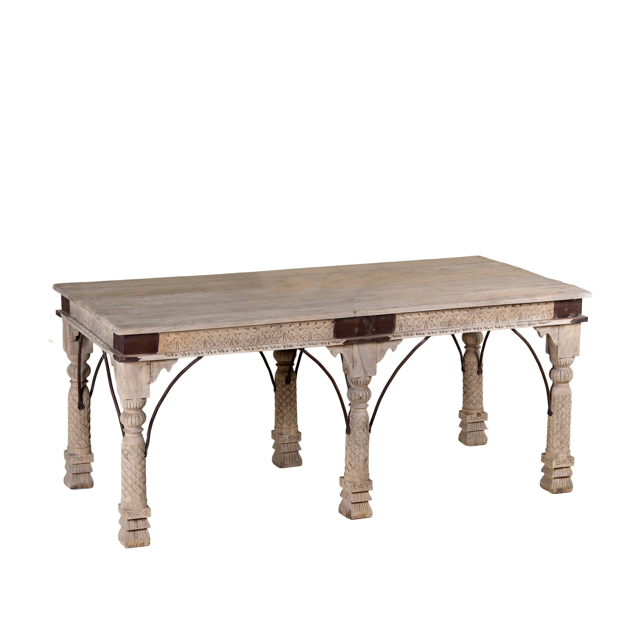 Side angle white background image of a teak wood dining table with six hand-carved pillar legs; reclaimed Indian dining table, 180 × 90 × 75 cm.