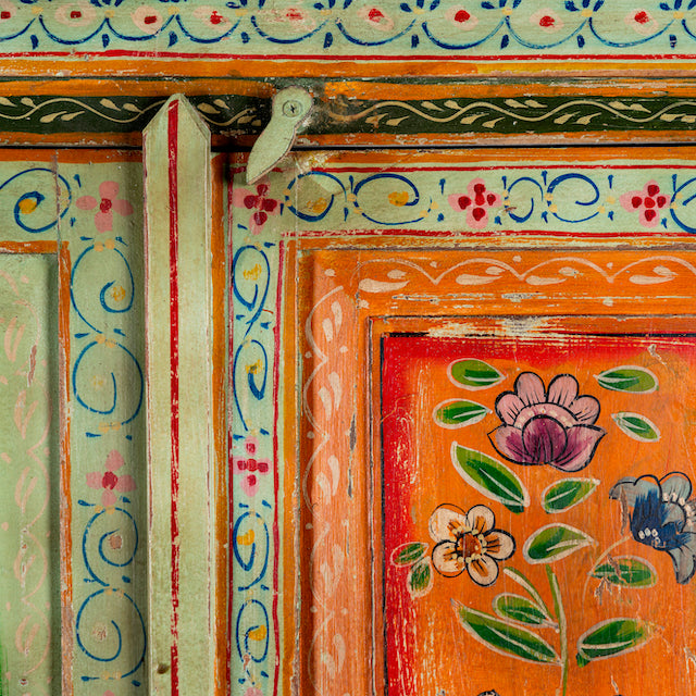Close up image of a hand-painted sustainable teak wood cabinet with floral motifs – Sangrur by Om Home & Garden, a one-of-a-kind piece of sustainable furniture with artistic expression.