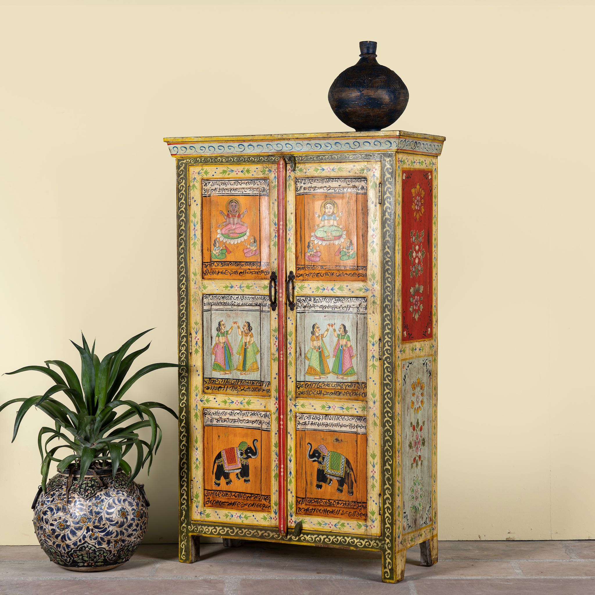 Side angle image of a hand-painted reclaimed wood cabinet with Indian gods, floral motifs, and distressed finish; unique furniture for vintage home decor, 90 × 40 × 150 cm.