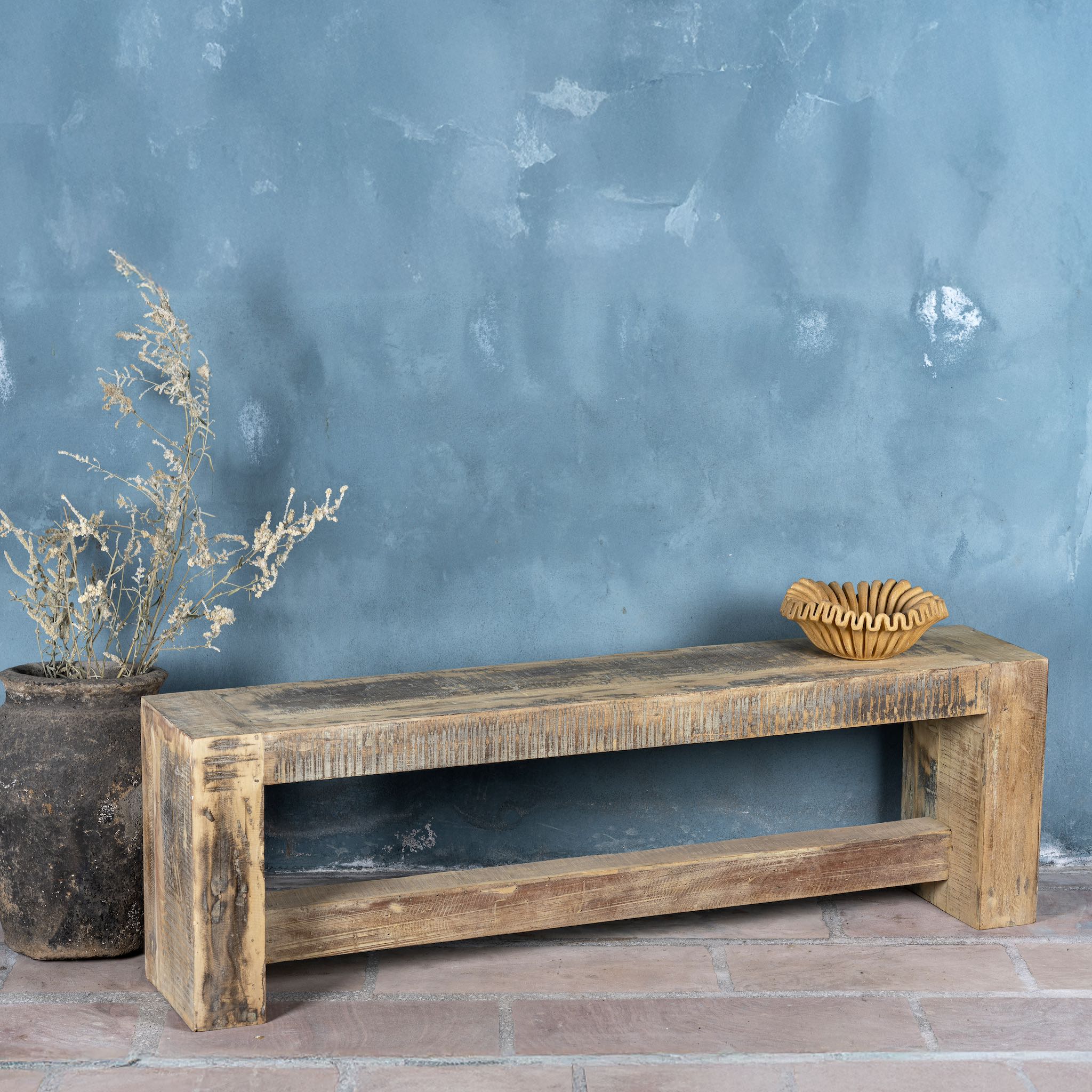 Side angle image of a reclaimed teak wood bench with rustic finish and minimalist frame; sustainable furniture, 160 × 30 × 50 cm.