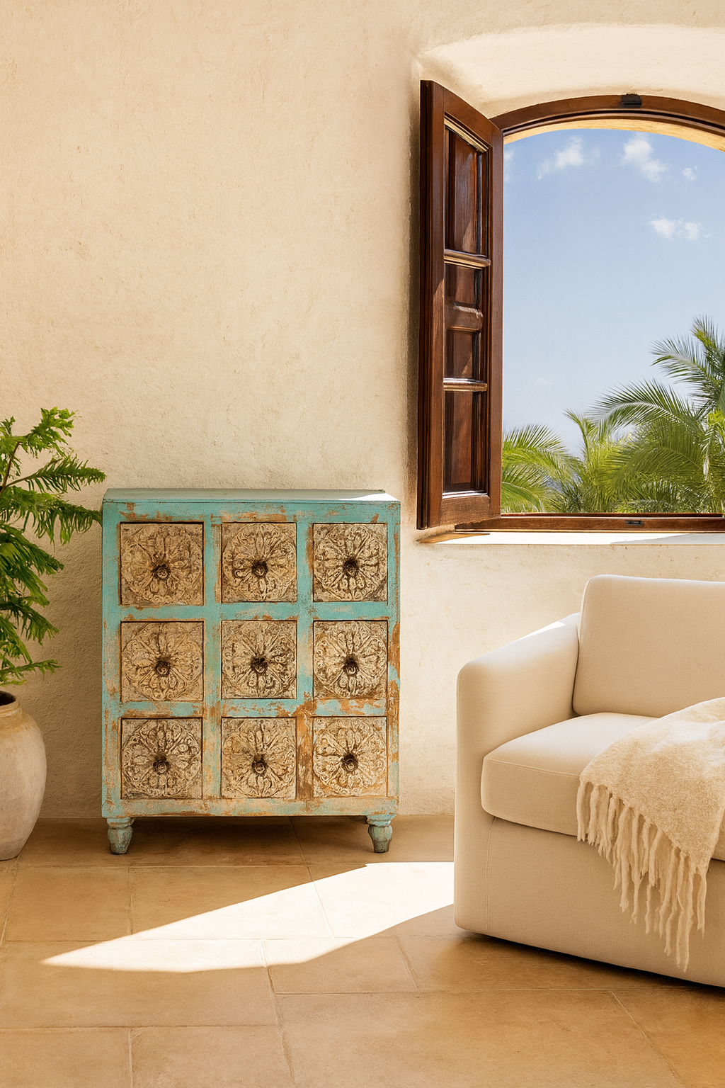 Lifestyle image of a hand-carved mango wood vintage chest of drawers with blue body and whitewashed floral fronts; perfect as an entryway table vintage accent, 90 × 100 × 40 cm.