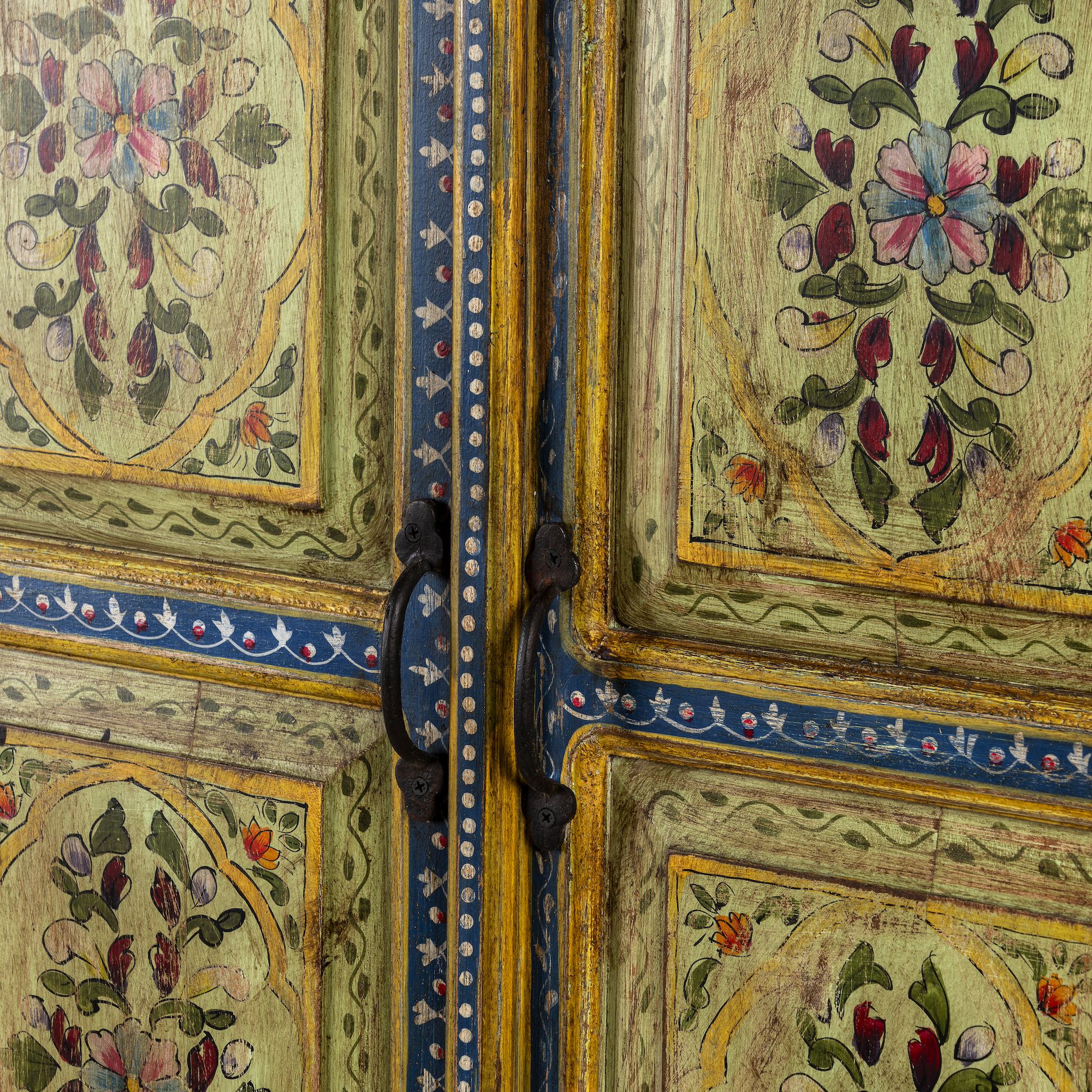 Close up picture of a hand painted wardrobe made from reclaimed wood with floral motifs and distressed finish; ideal for a boho chic living room or eclectic bedroom, 90 × 40 × 150 cm.