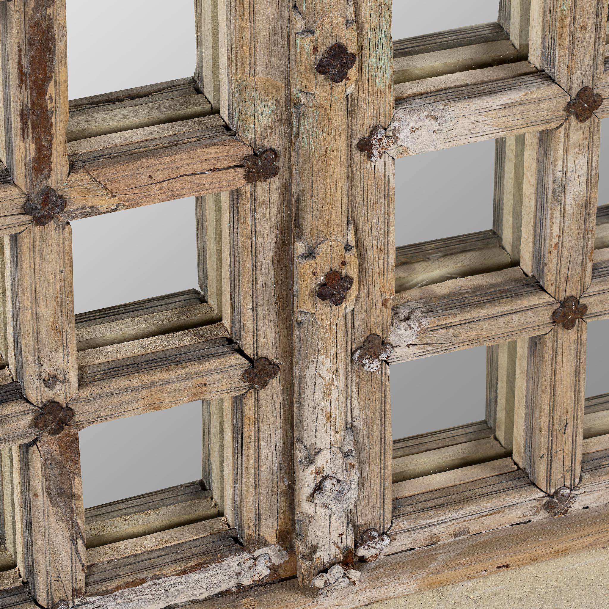 Close up image of a antique teakwood mirror made from a traditional Indian door with iron details and mirror inlays – perfect as a reclaimed wood mirror for vintage home decor.