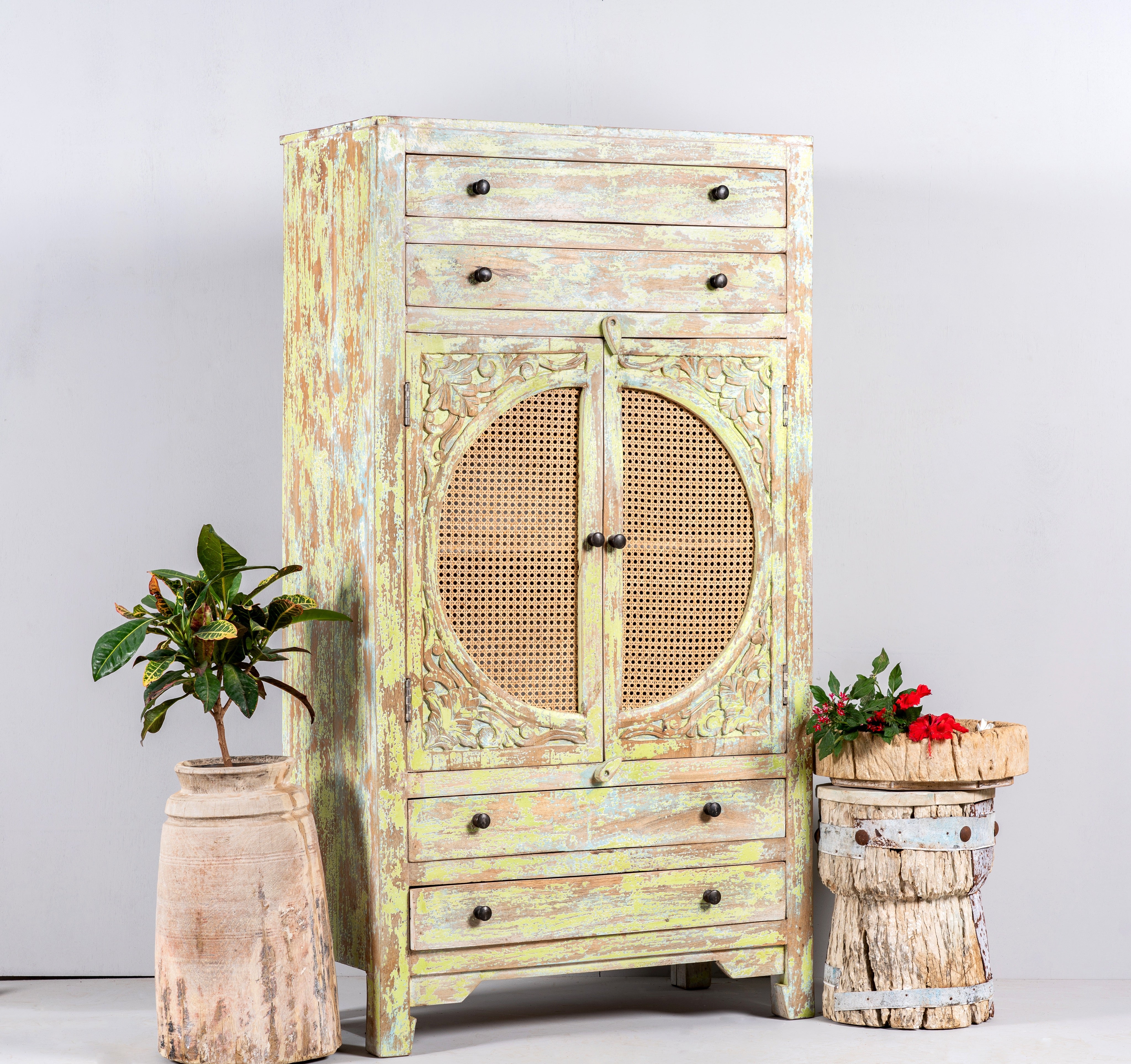 Side angle image of a green-washed mango wood cabinet with floral carvings, rattan door inserts, versatile living room furniture, 80 × 148 × 40 cm.