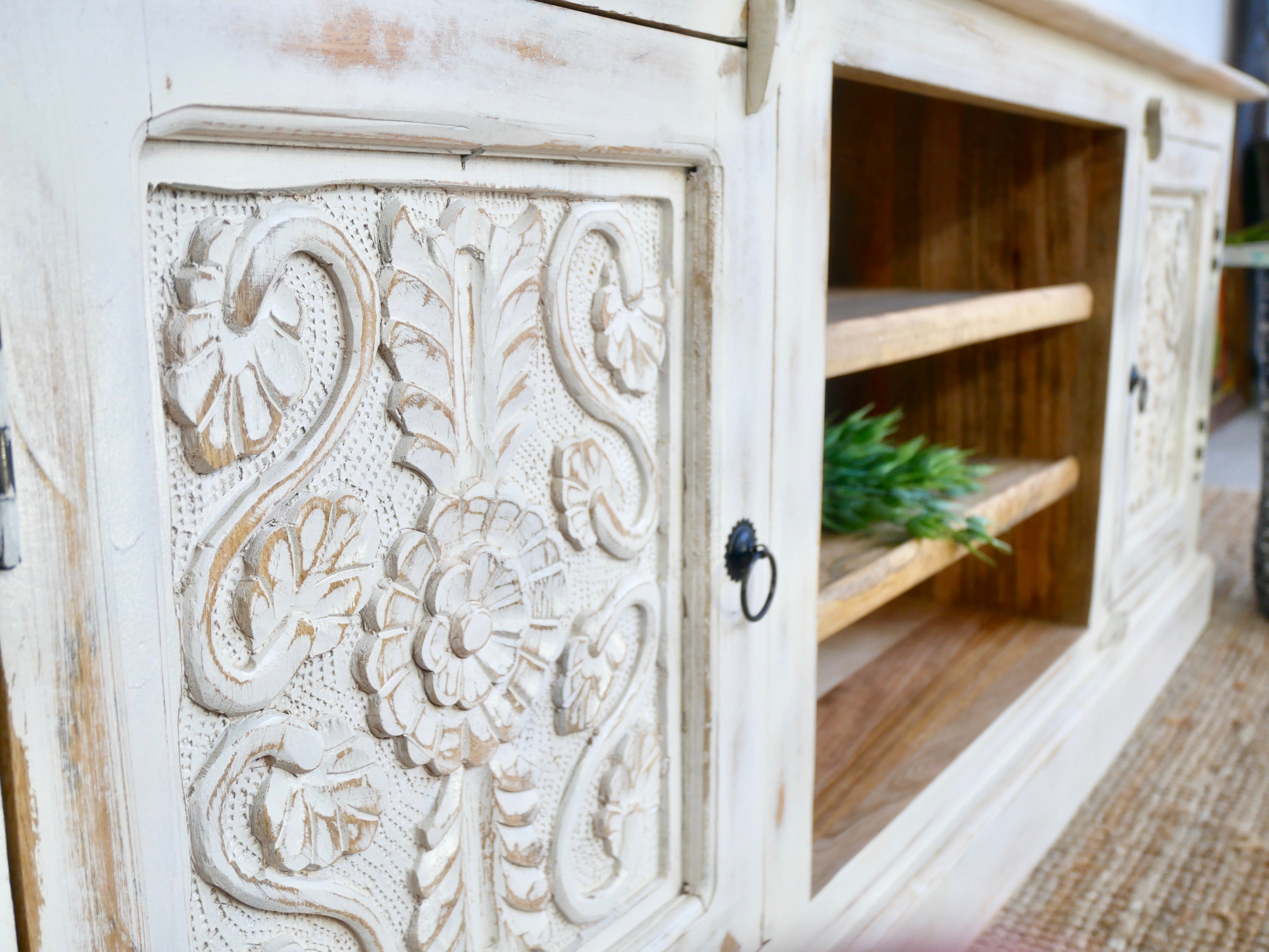 Close up image of a hand carved lowboard made from mango wood with floral doors and open compartments; wooden TV unit, 150 × 60 × 40 cm.